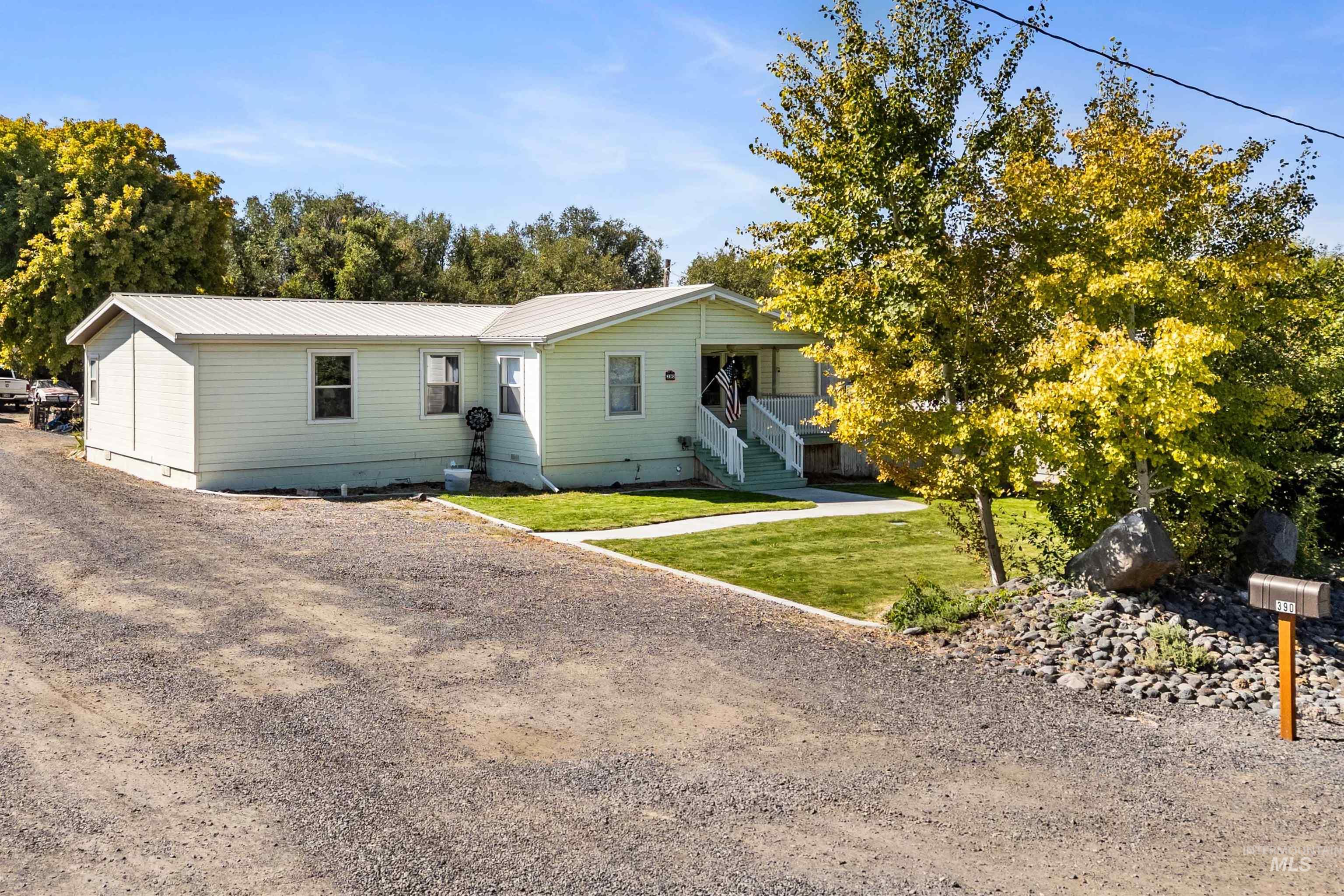 Back of house featuring a metal roof, a yard, driveway, and crawl space