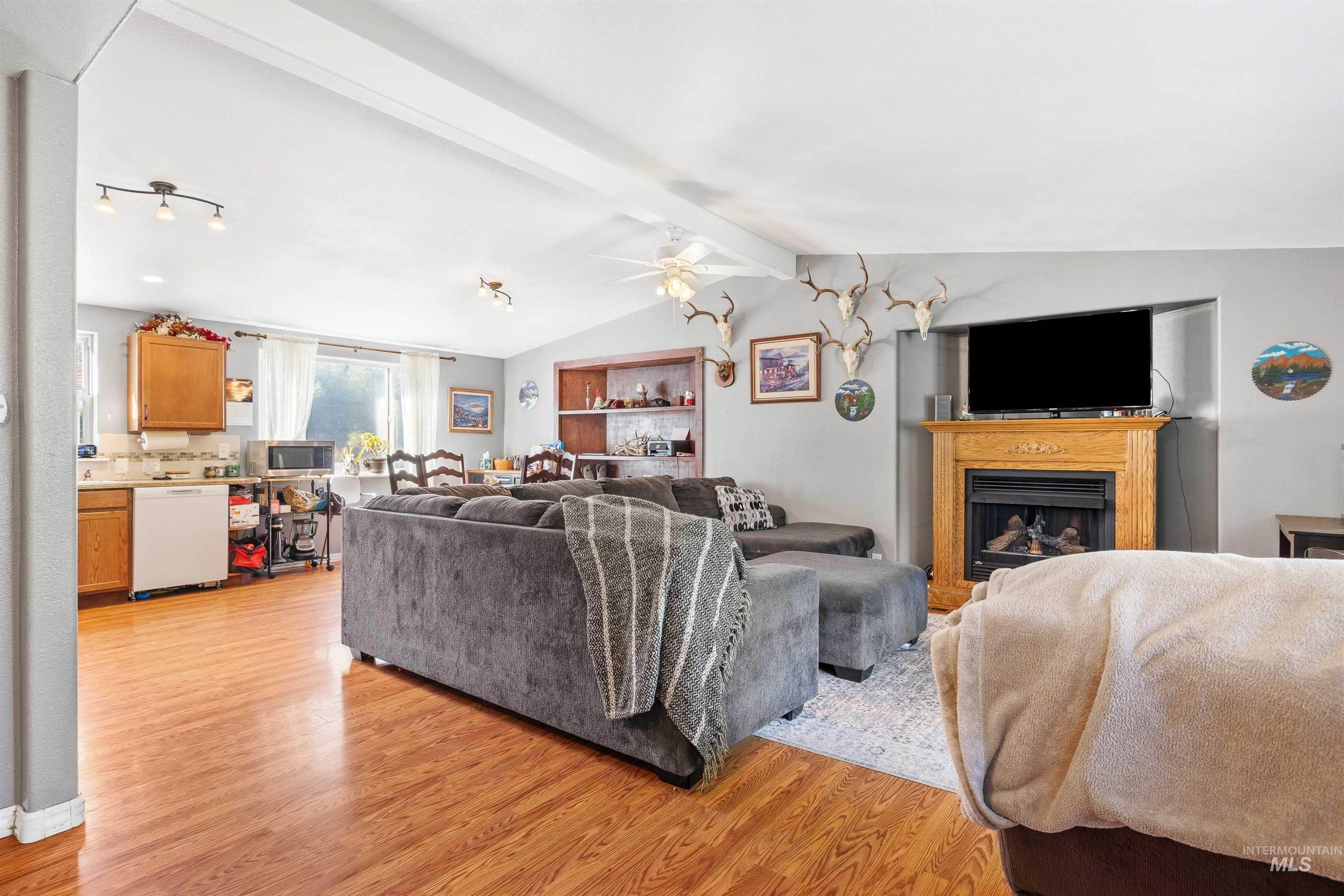 Living area featuring light wood-type flooring, a fireplace, and ceiling fan