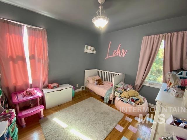 Bedroom featuring wood finished floors and baseboards