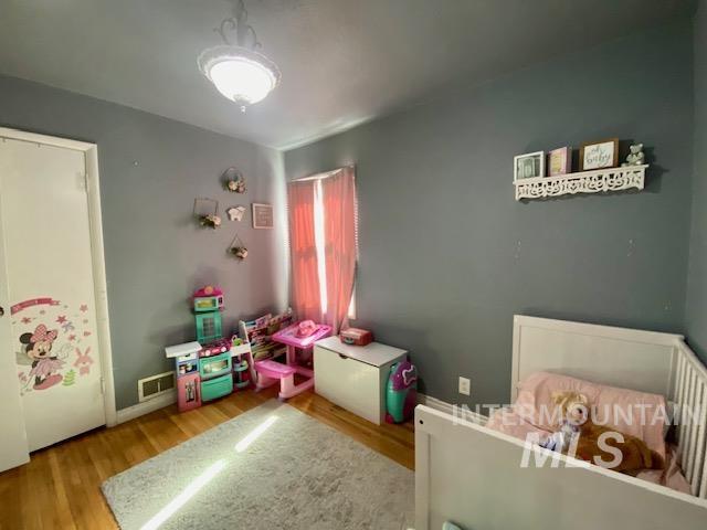 Bedroom with wood finished floors and baseboards