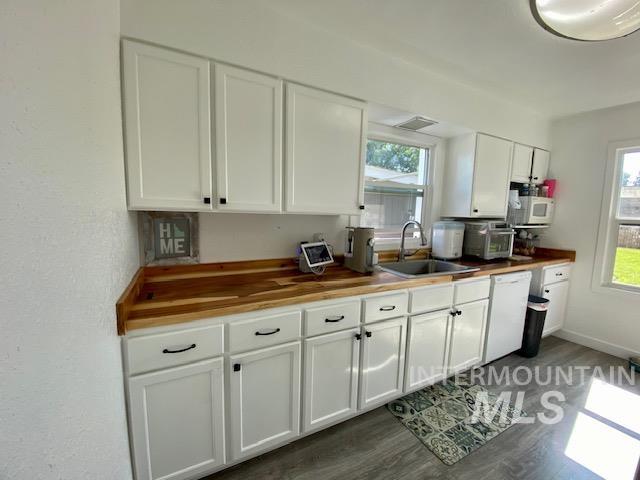 Kitchen with white cabinetry, wooden counters, dark wood finished floors, and white appliances