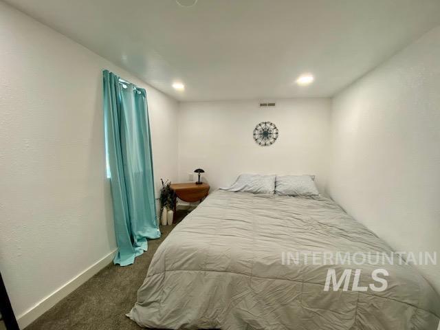 Bedroom with dark colored carpet and recessed lighting