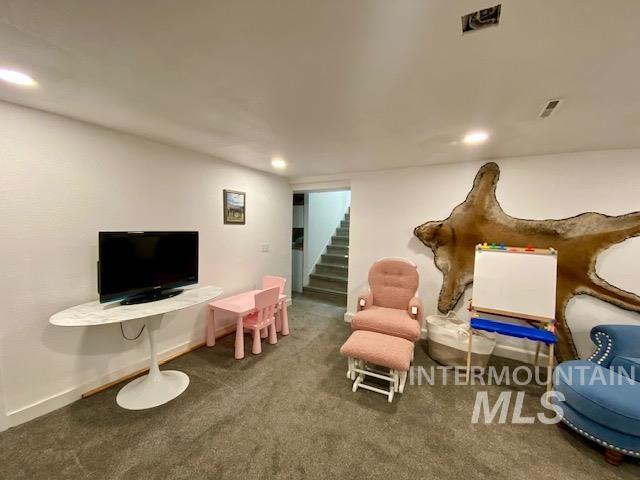 Living area featuring carpet floors, stairs, and recessed lighting