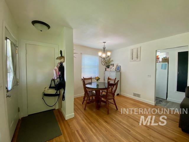 Dining area with light wood-style flooring and a chandelier