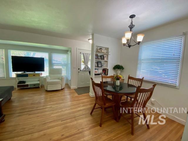 Dining space featuring light wood-style flooring, a chandelier, and healthy amount of natural light