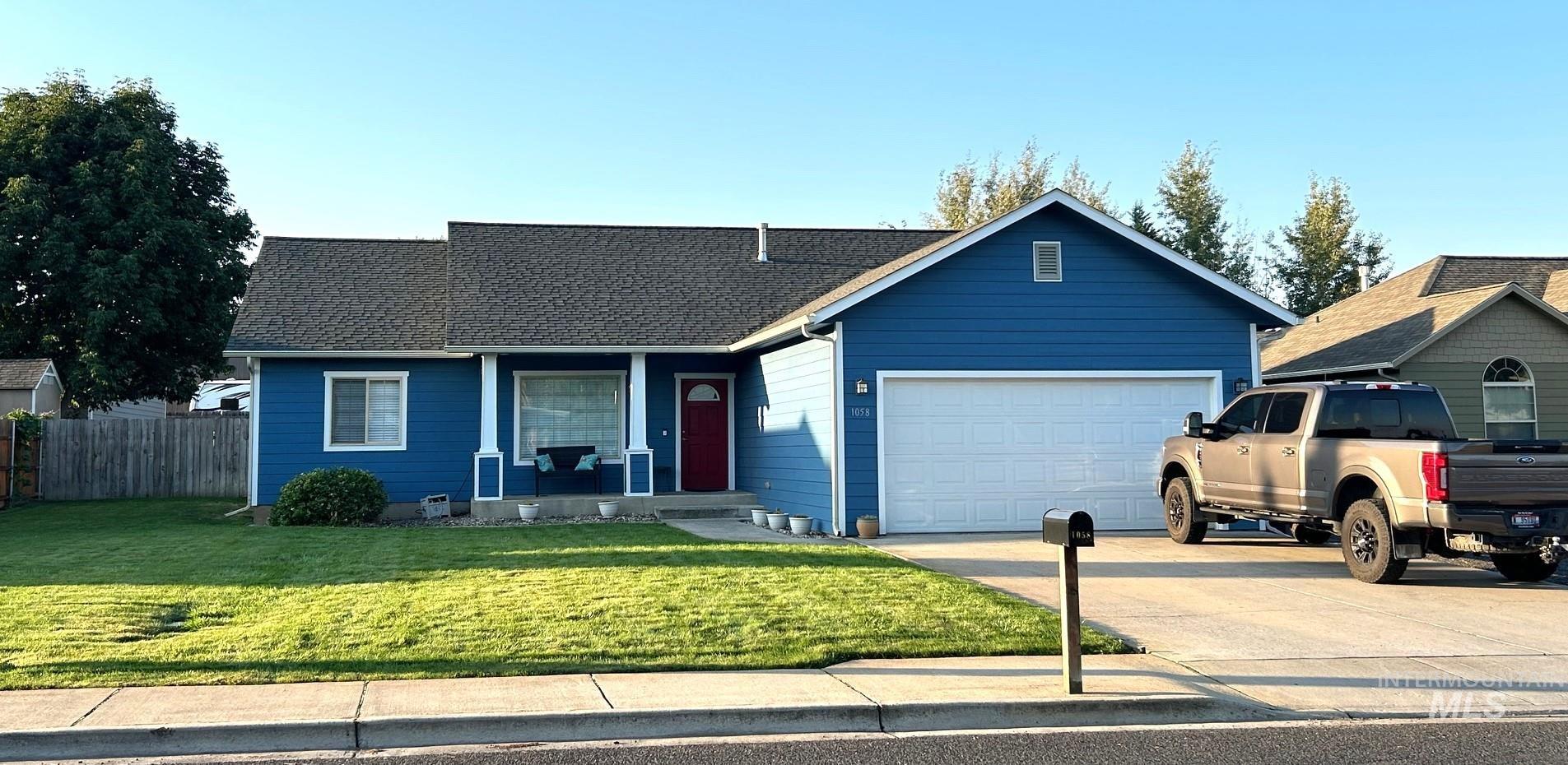View of front of home with concrete driveway, a shingled roof, and a garage