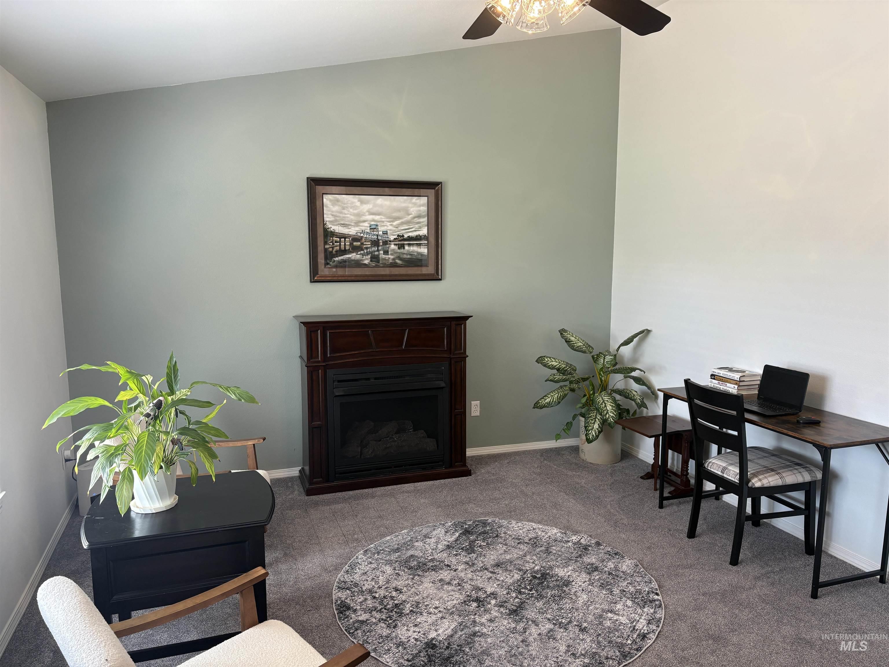 Carpeted office featuring a fireplace and baseboards