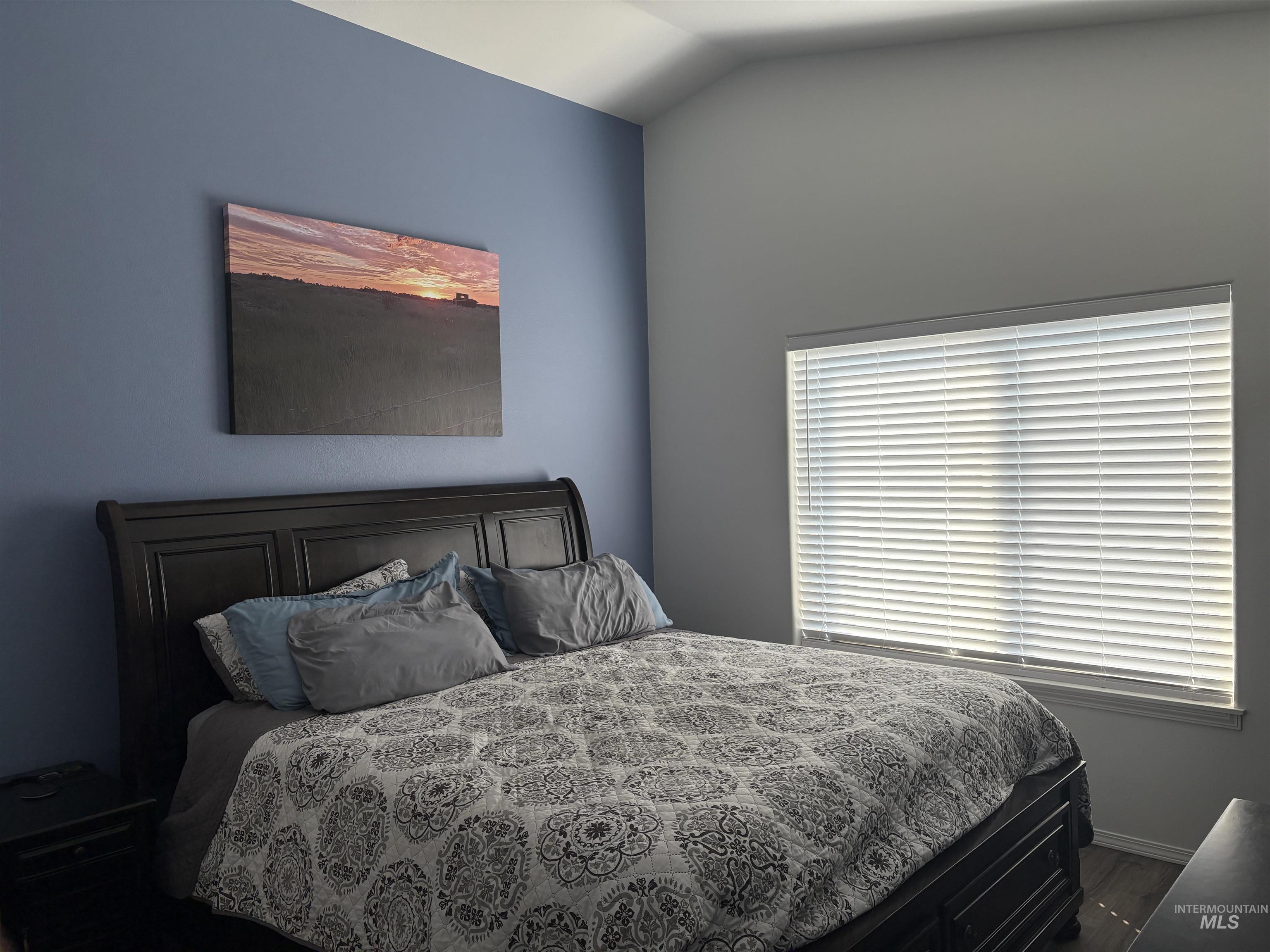 Bedroom featuring dark wood-style floors and vaulted ceiling
