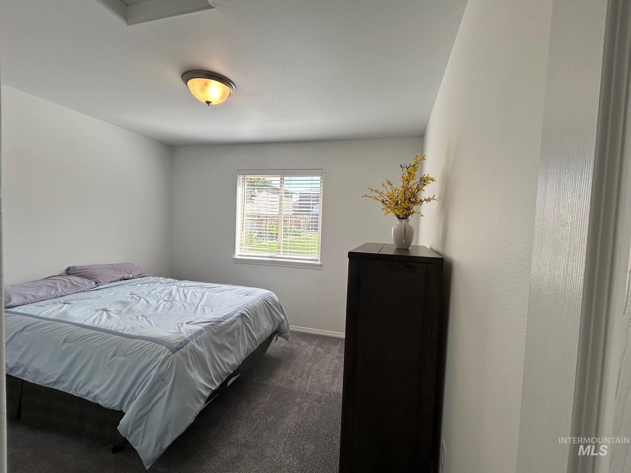 Bedroom featuring carpet flooring and baseboards