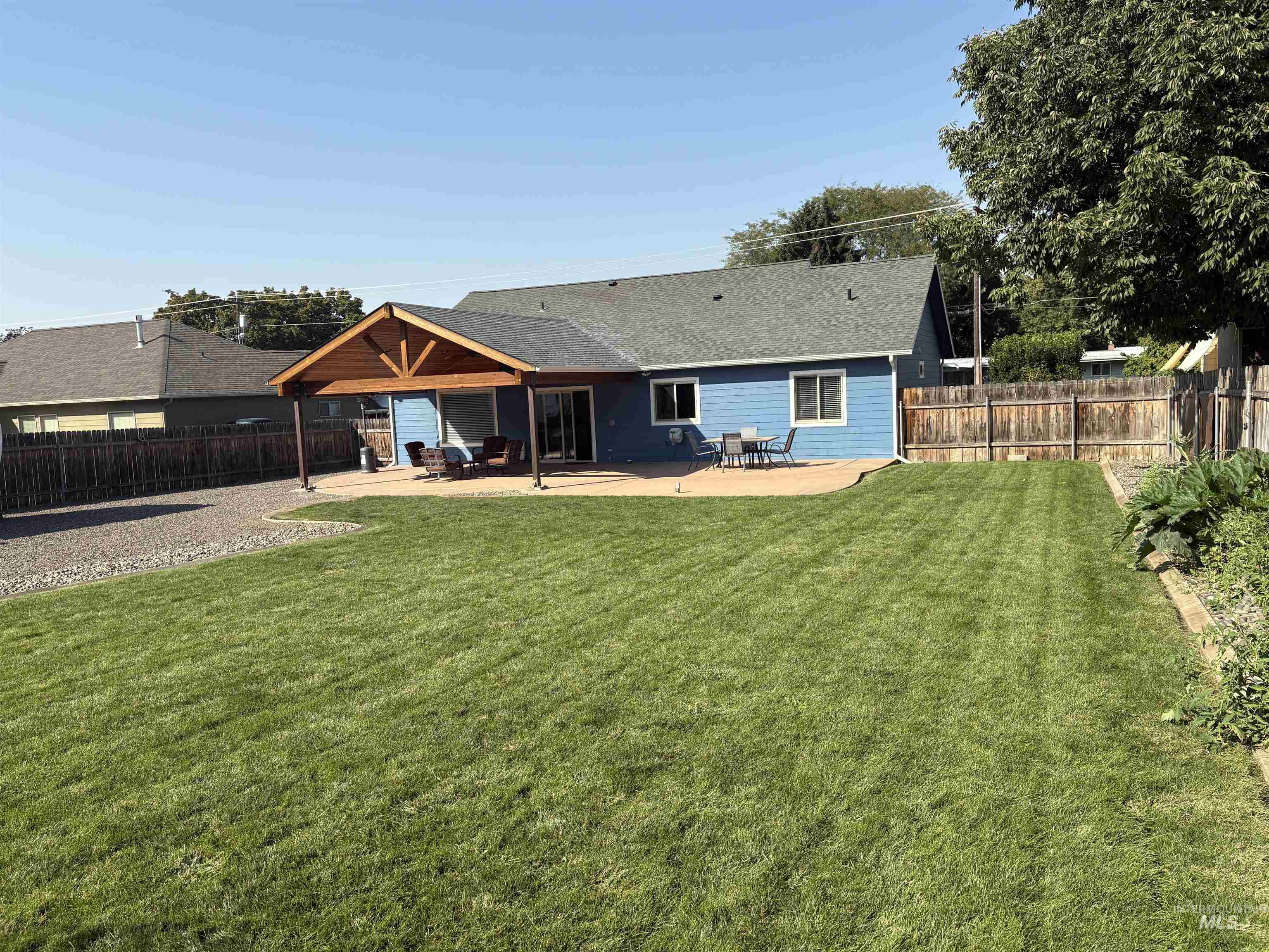 Rear view of property featuring a patio, a fenced backyard, and roof with shingles