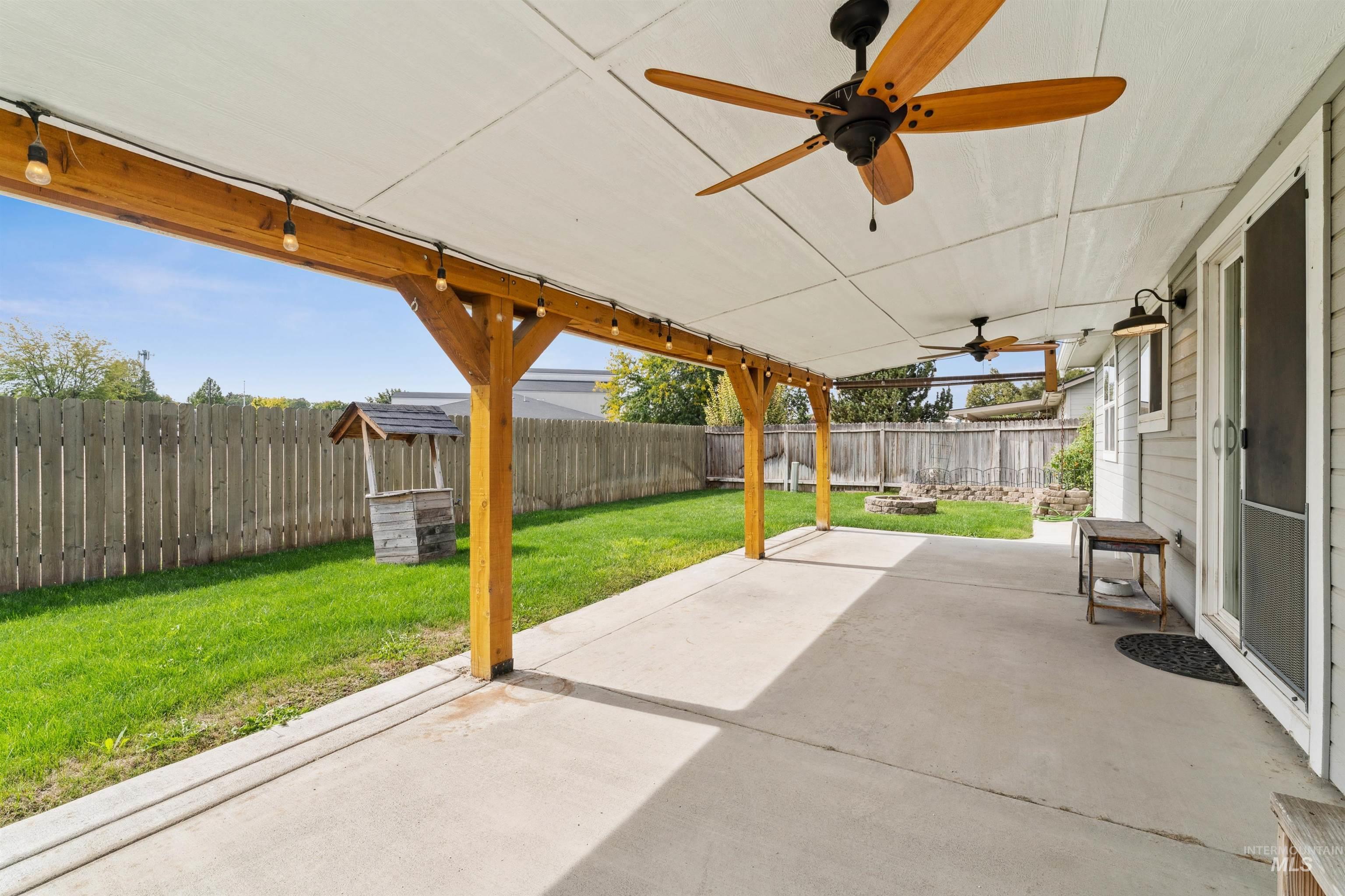Fenced backyard featuring a patio and ceiling fan