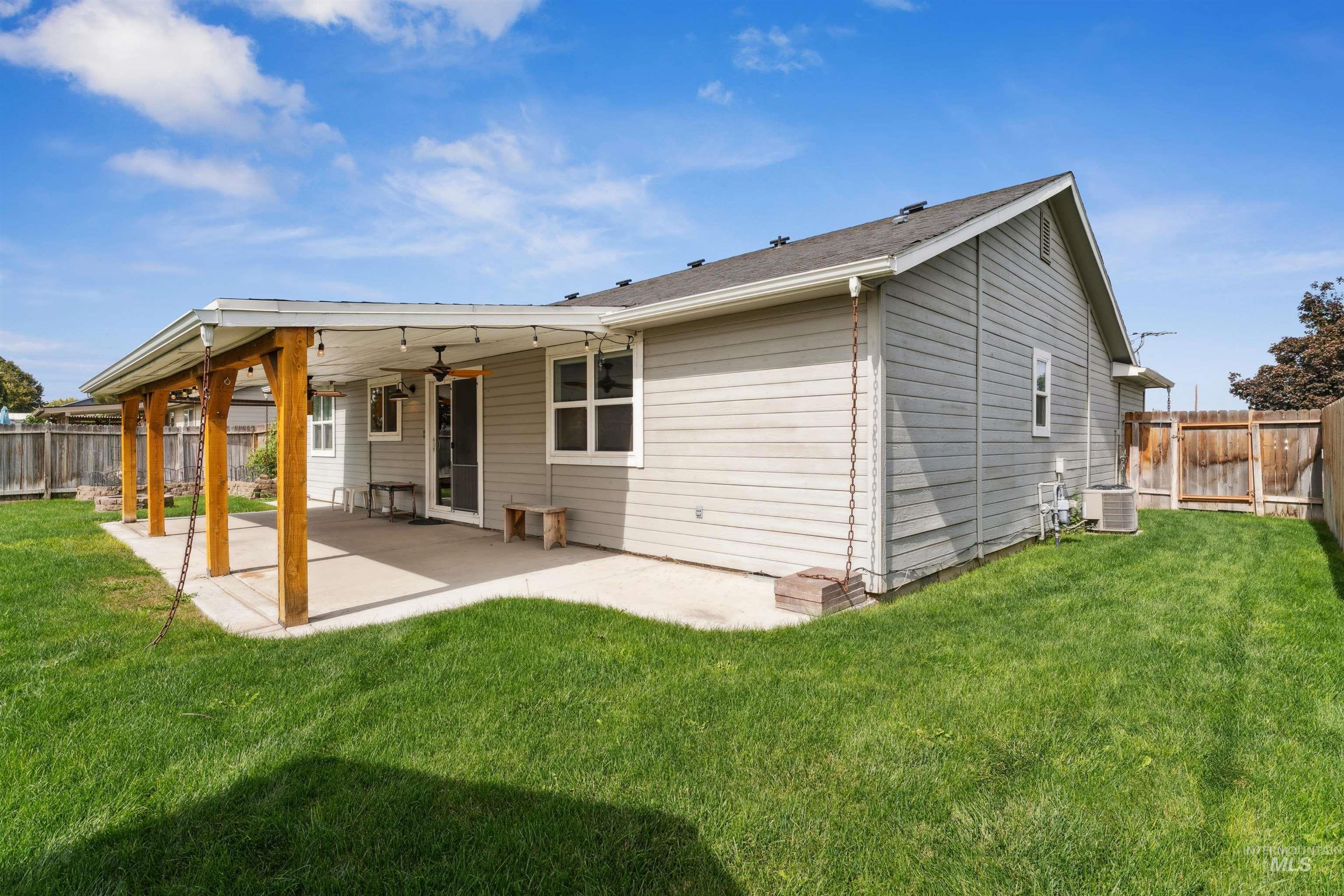 Rear view of house featuring a fenced backyard, a patio, and a ceiling fan