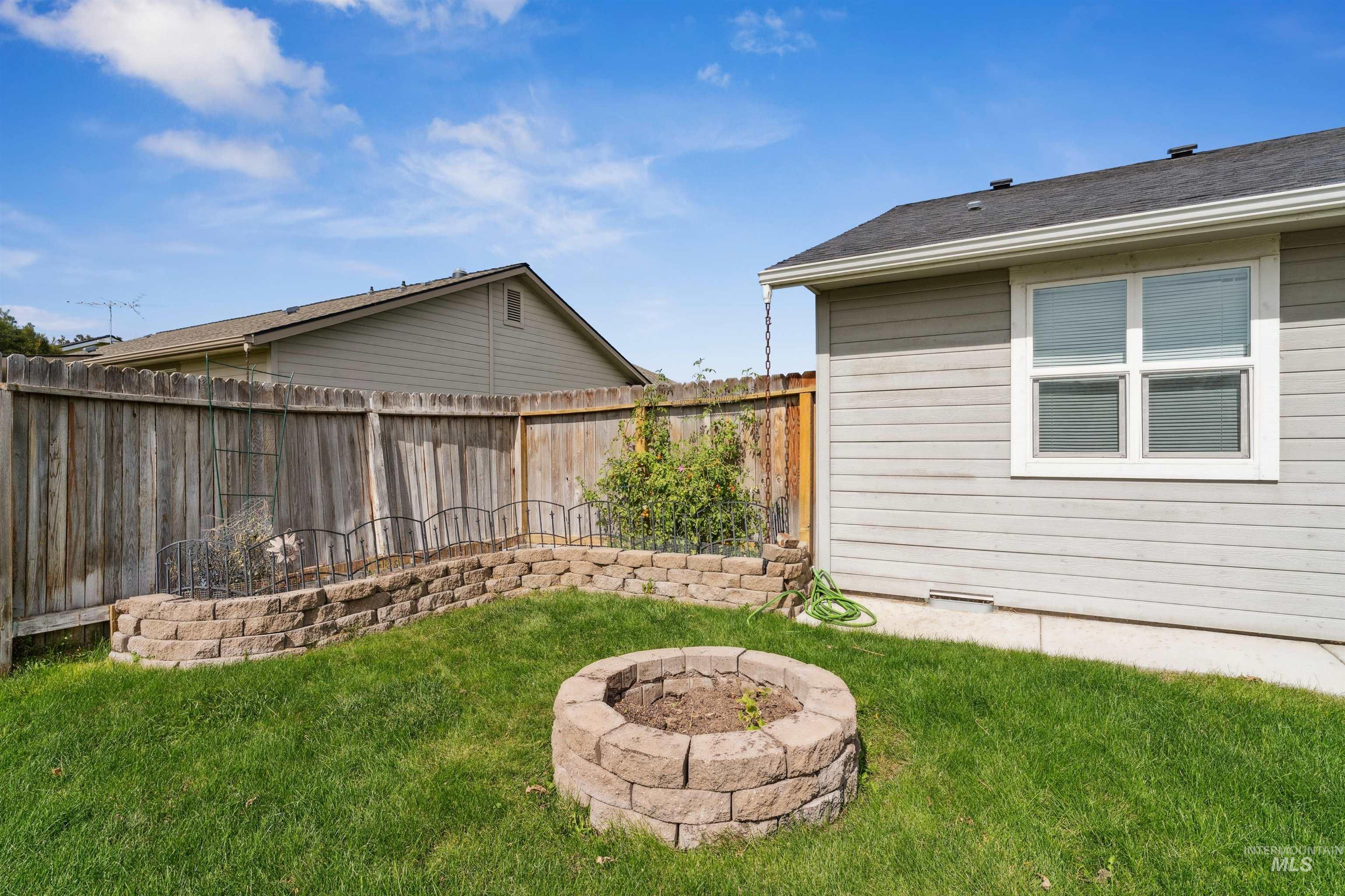 Fenced backyard with an outdoor fire pit