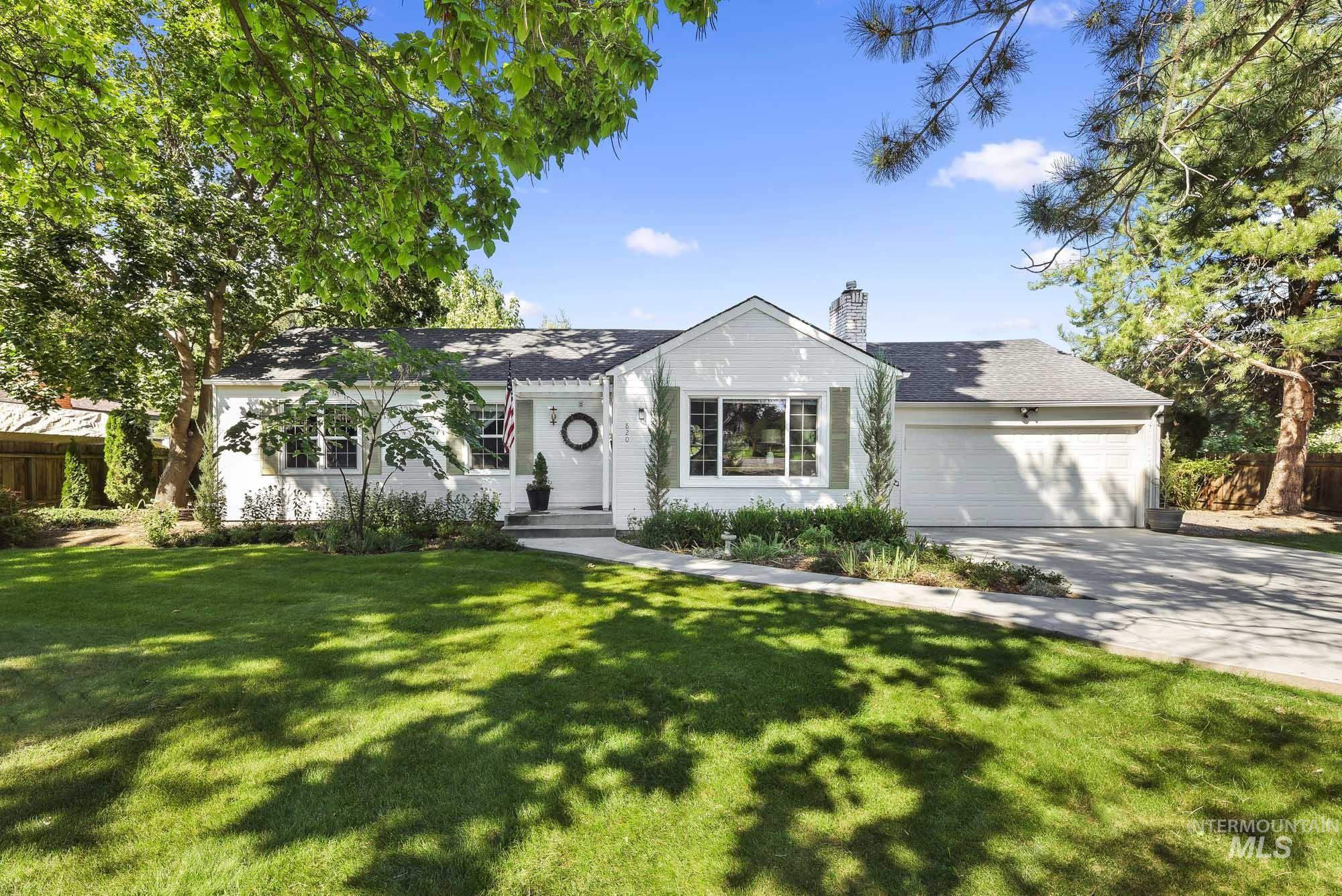 Single story home with a chimney, concrete driveway, a garage, a front yard, and a shingled roof