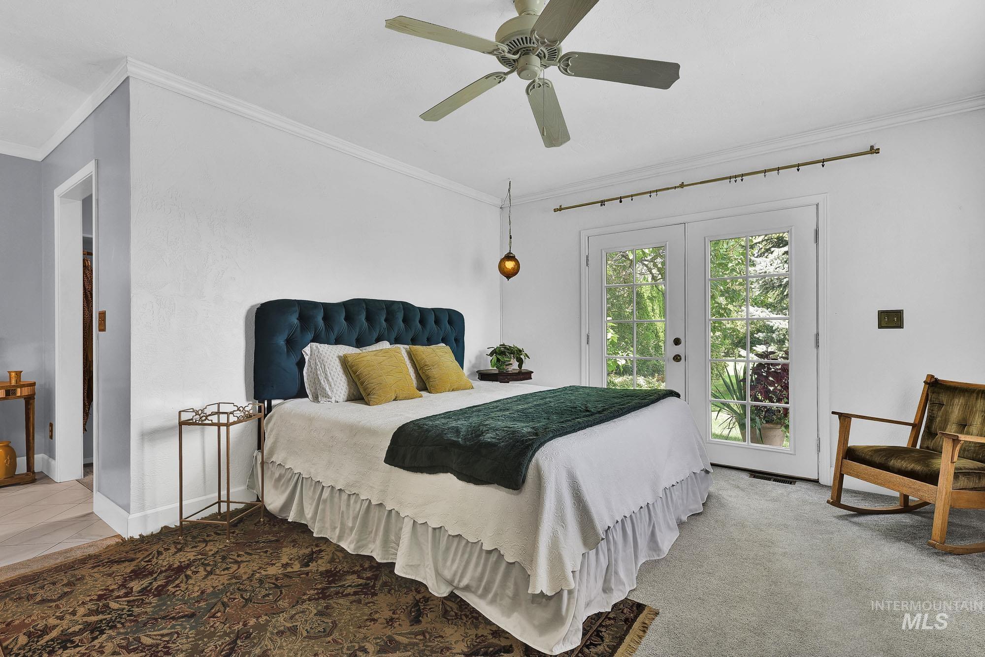 Bedroom with crown molding, access to exterior, a ceiling fan, french doors, and carpet flooring