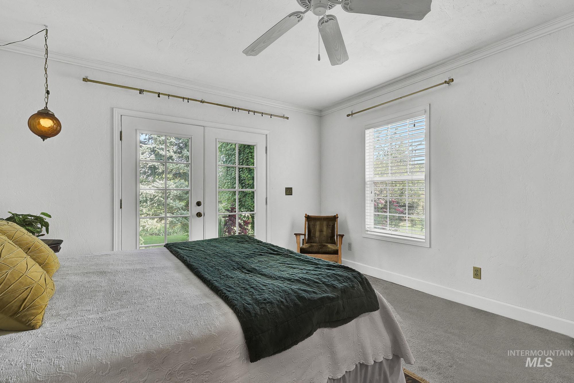 Primary bedroom featuring crown molding, french door access to exterior, and ceiling fan