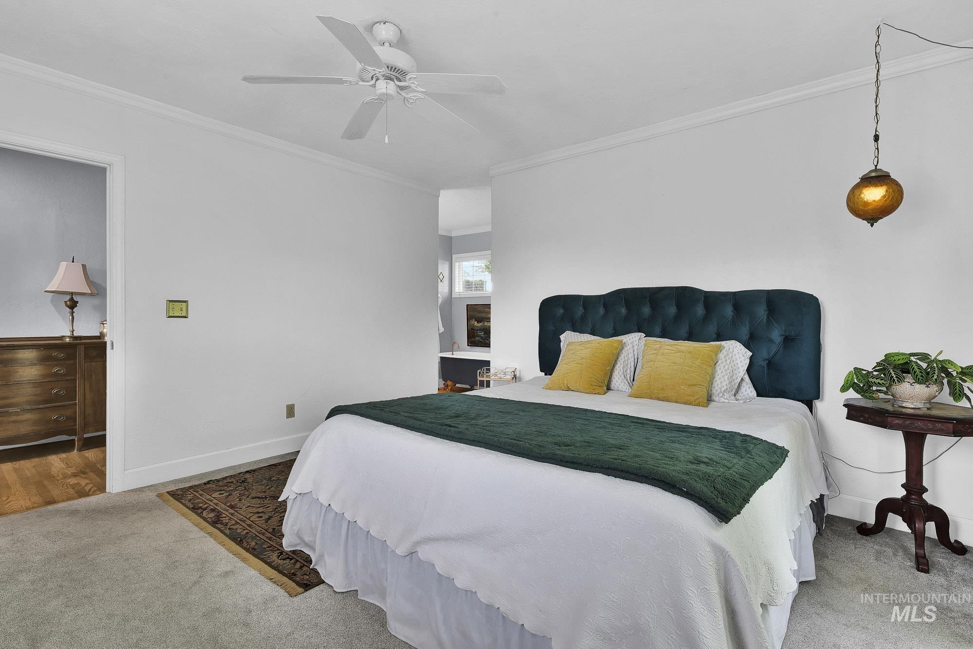 Bedroom with crown molding, light carpet, a ceiling fan and lots of natural light