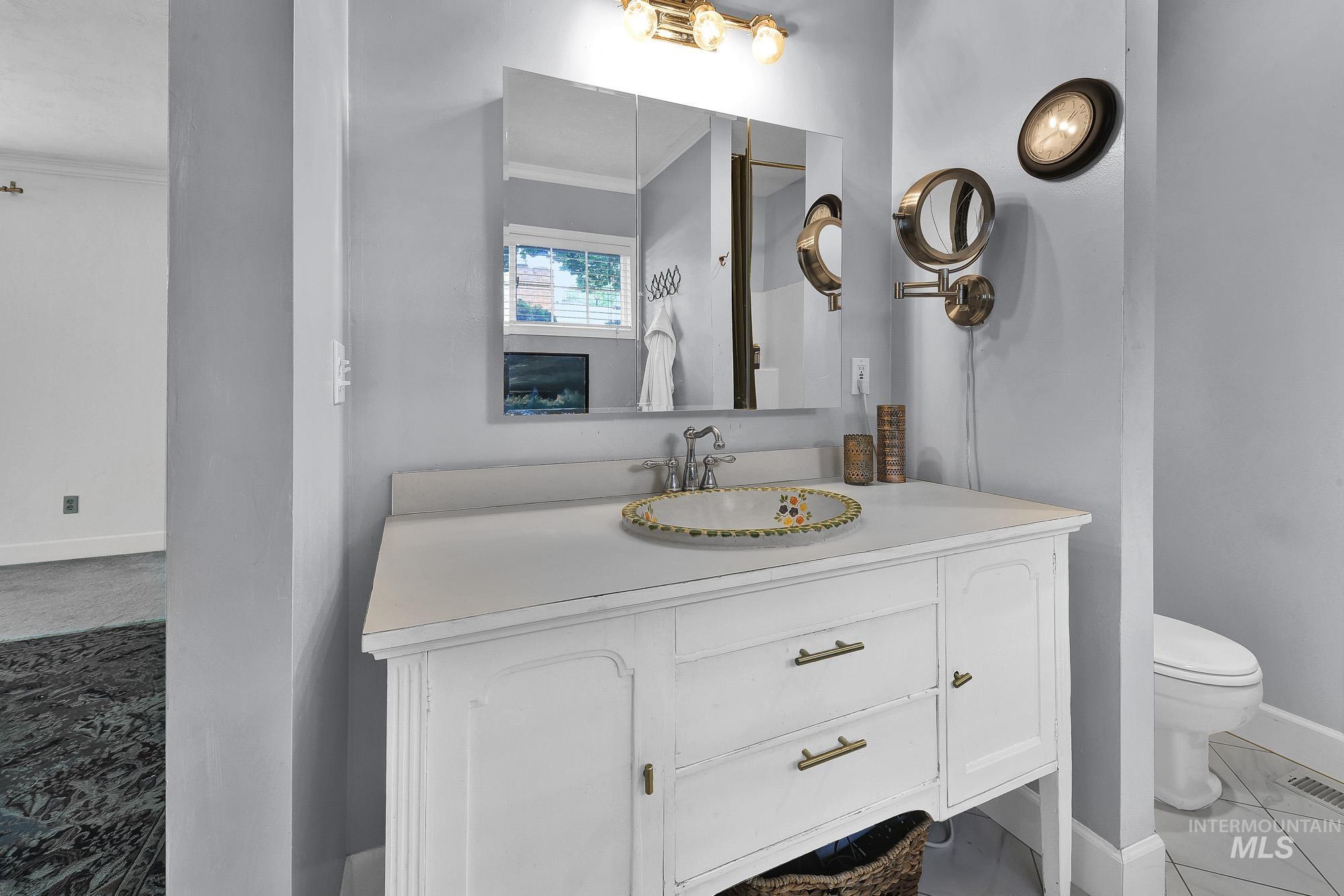 Bathroom featuring ornamental molding, unique oversized vanity and light tile patterned floors