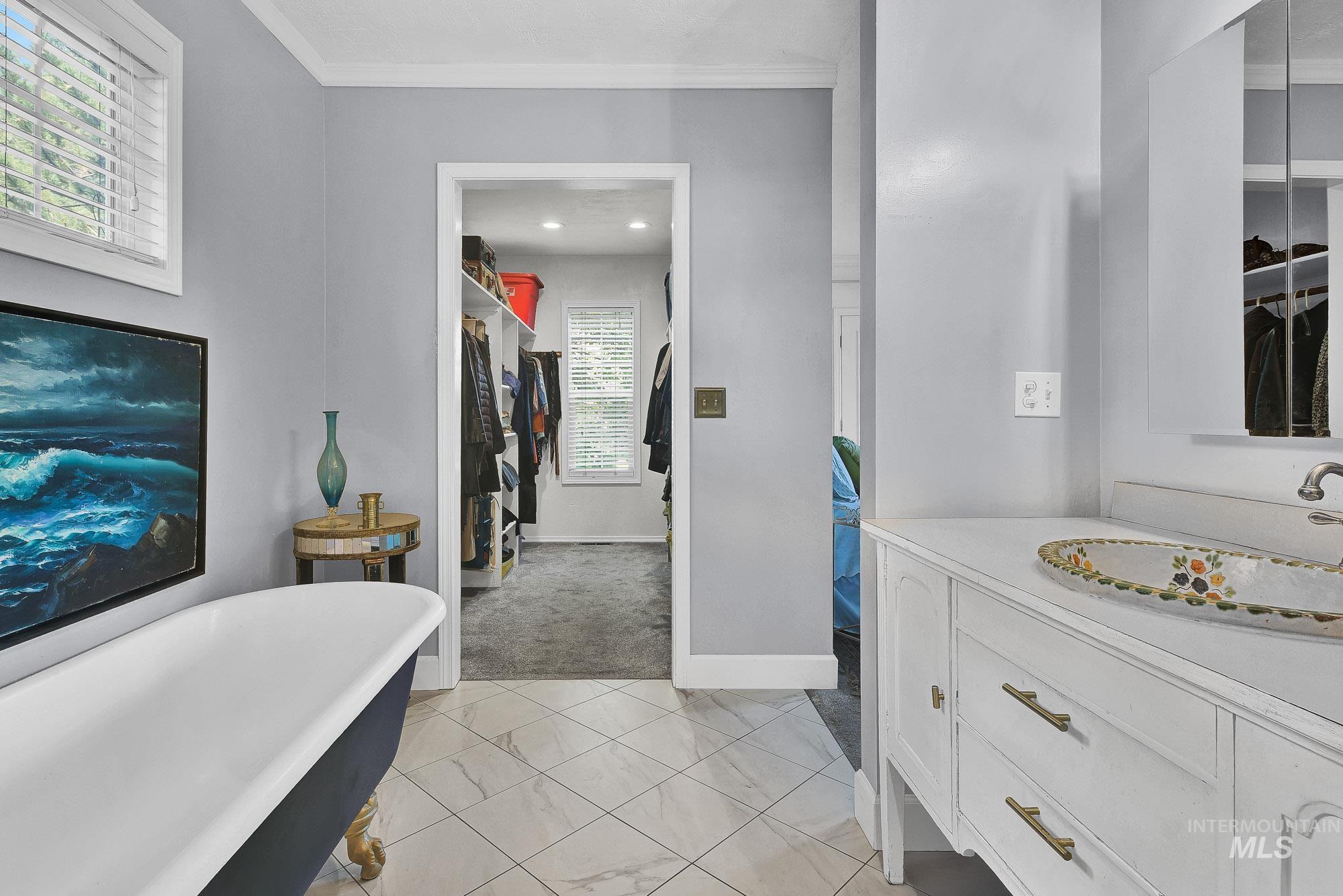 Full bath featuring a huge walk in closet, vanity, a soaking tub and separate shower