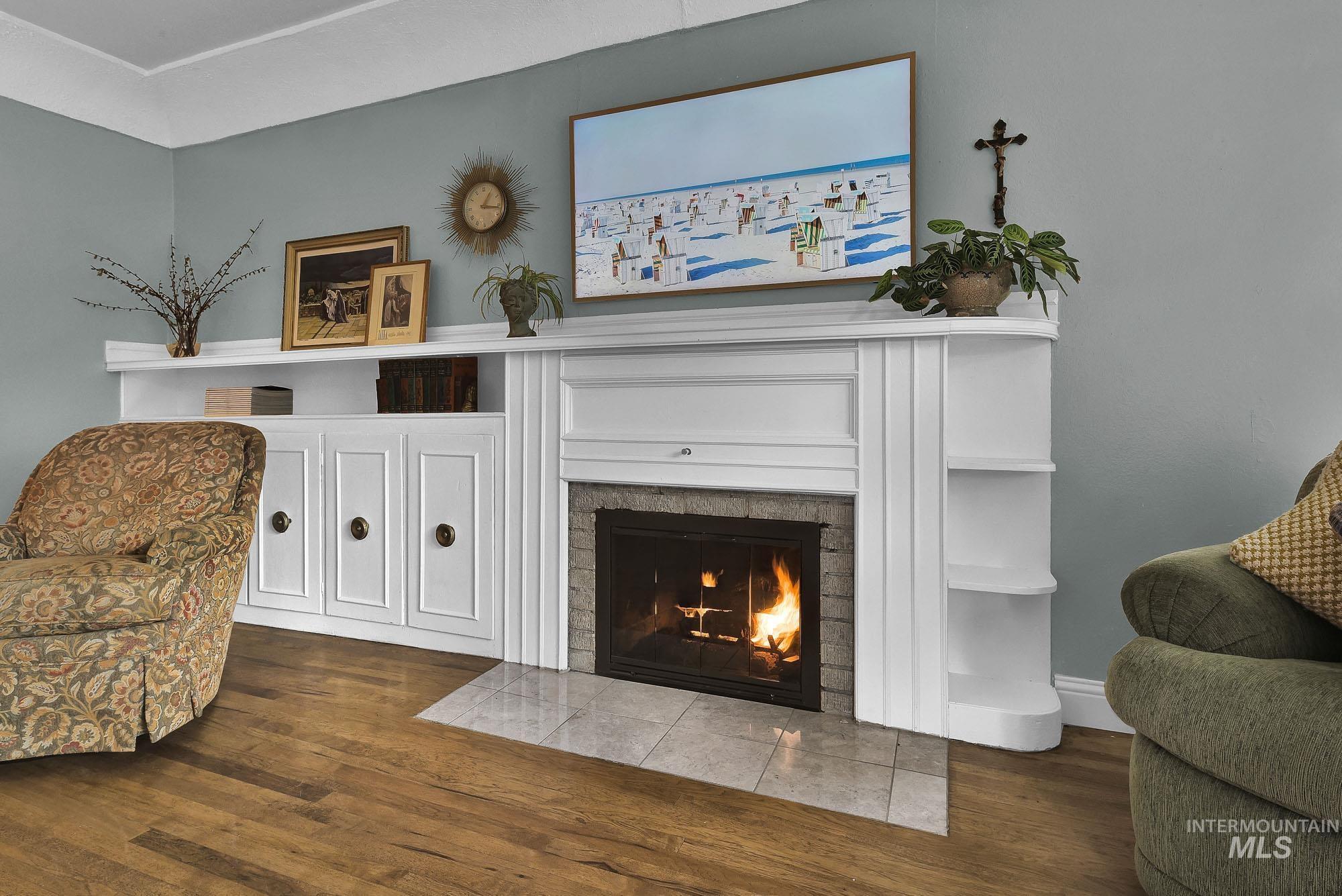 Living area with wood finished floors and a fireplace with flush hearth gorgeous built ins surrounding the fireplace