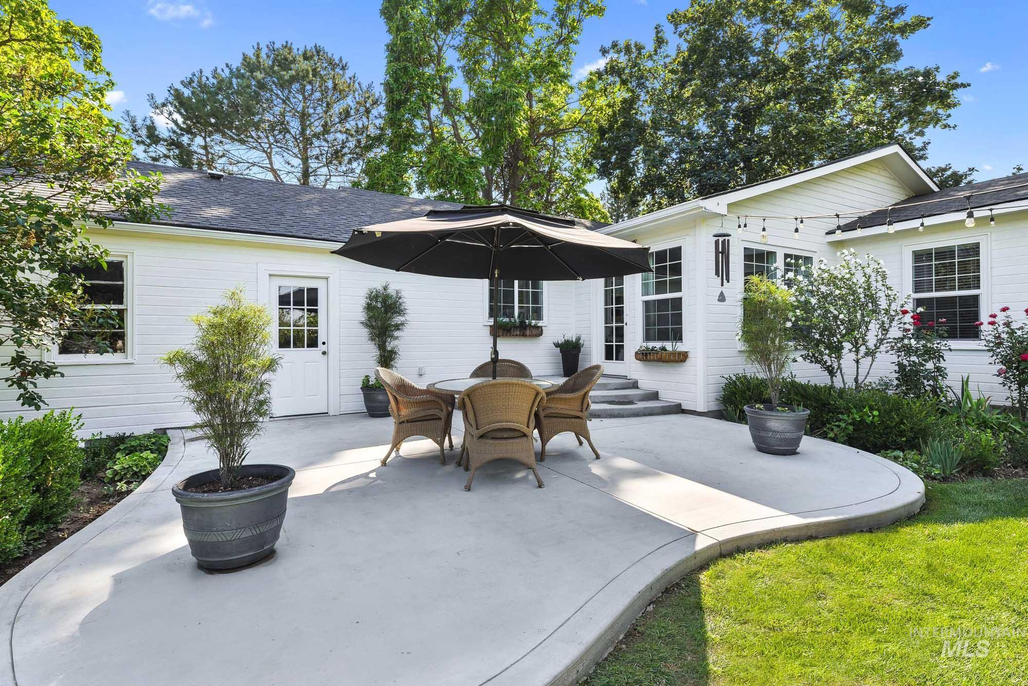 Back of property with an oversized patio area and outdoor dining area