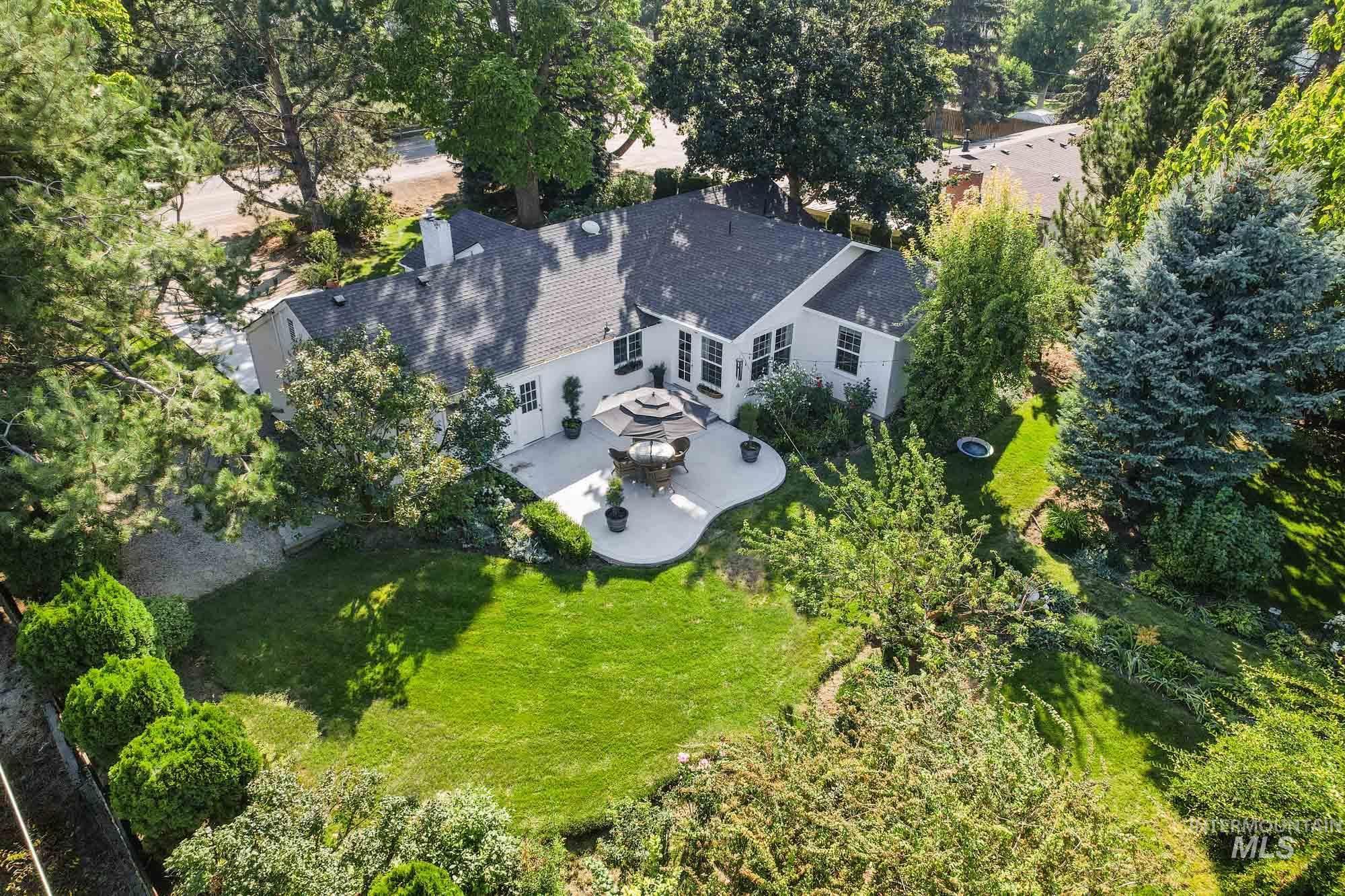 Aerial view of property - back patio and surrounding area with a tree filled landscape