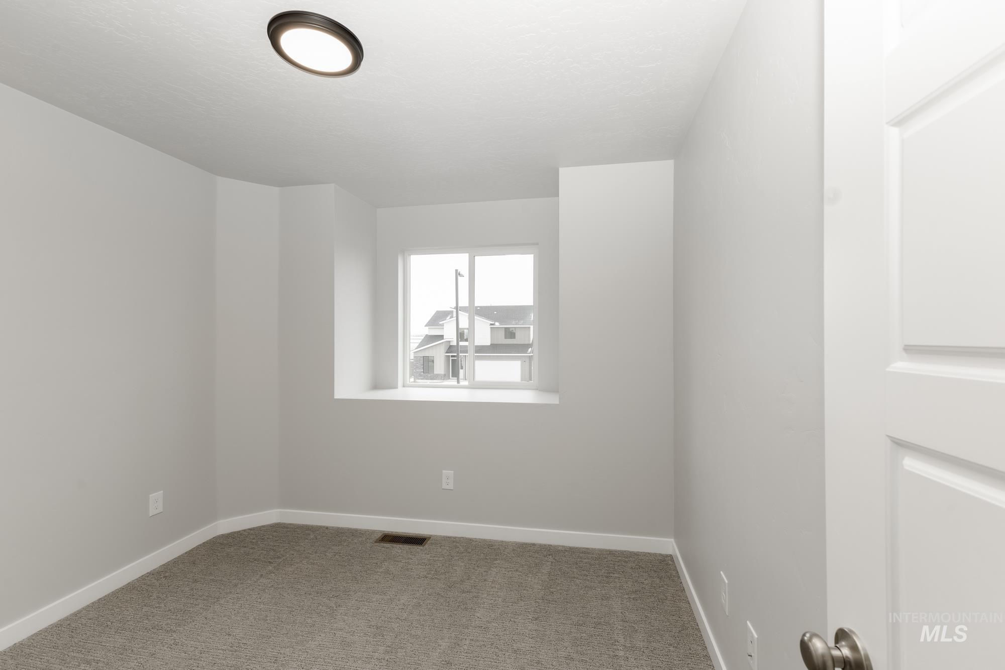 Empty room with carpet flooring and baseboards