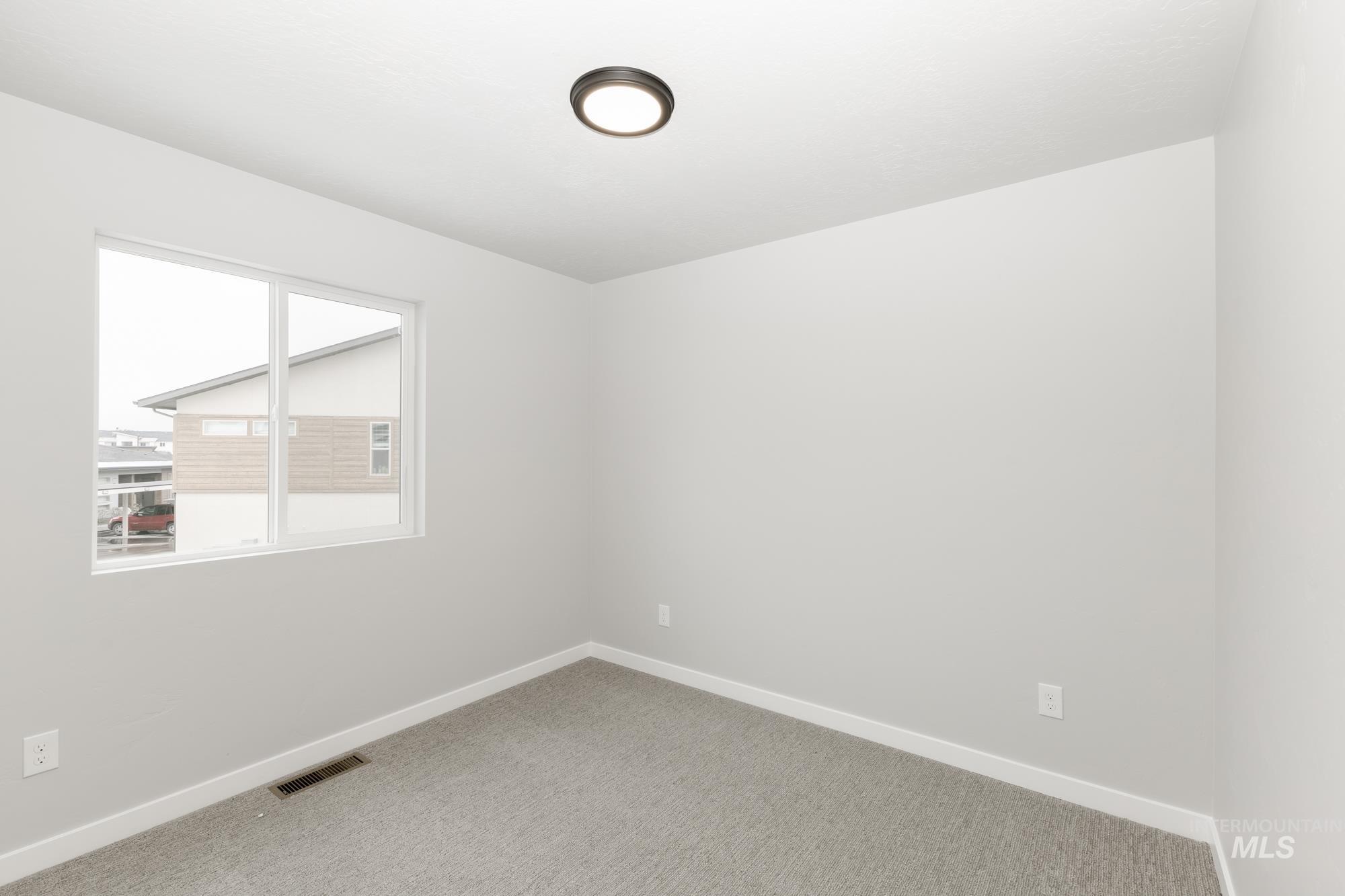Empty room with light carpet and baseboards