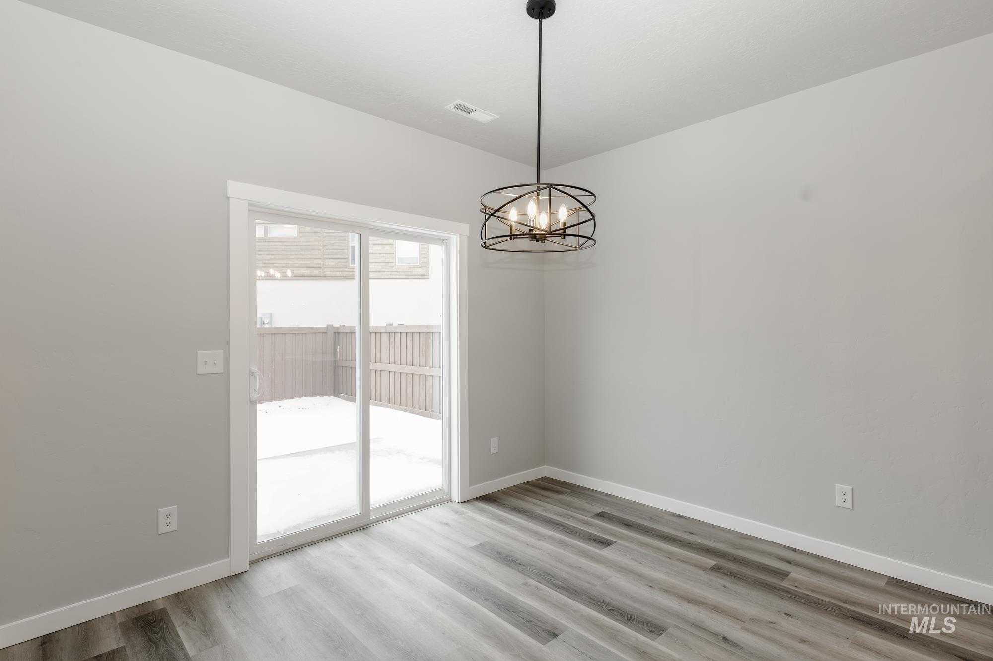 Unfurnished dining area featuring light wood-style floors and a chandelier