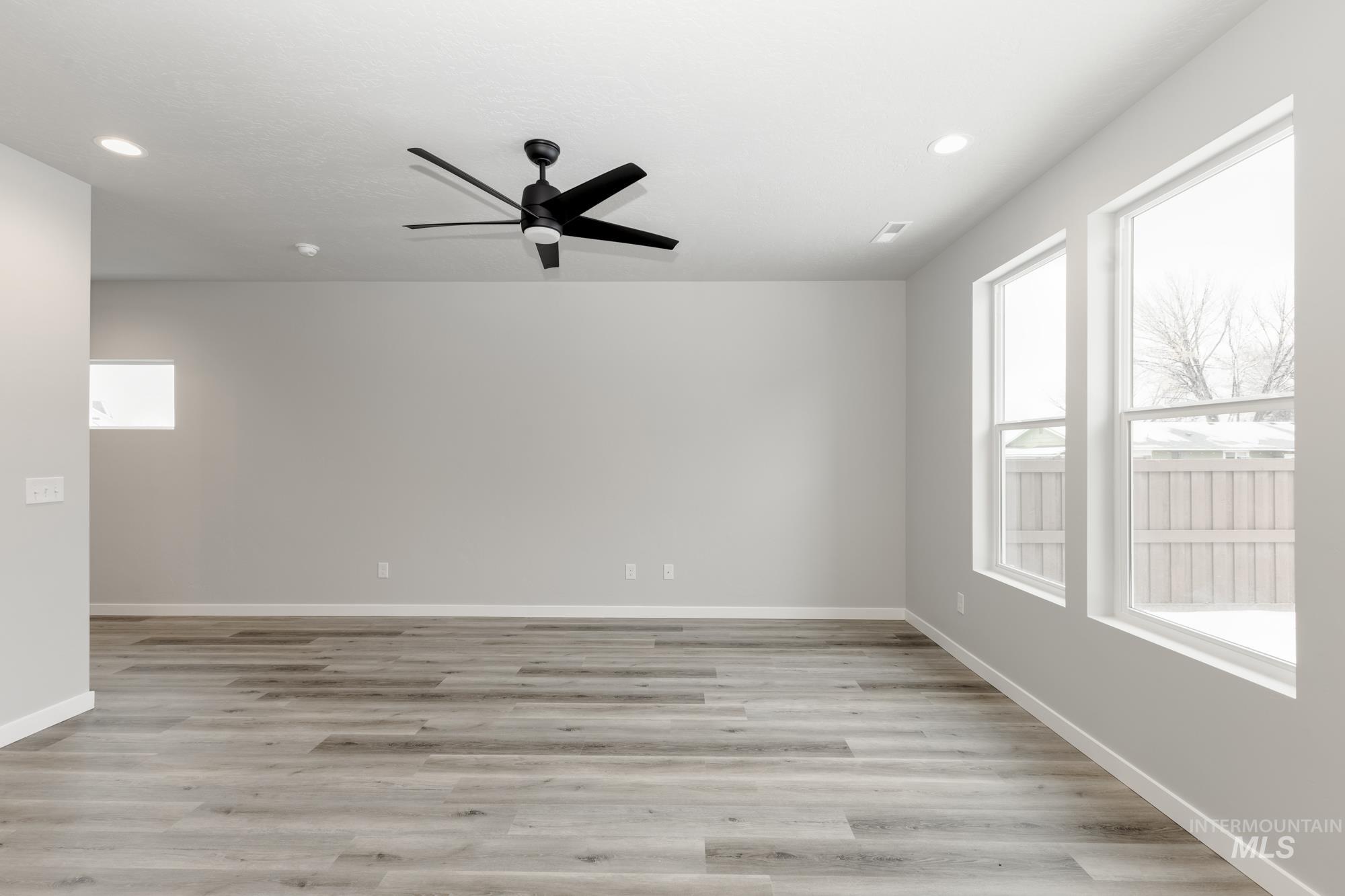 Empty room with light wood finished floors, a ceiling fan, and recessed lighting