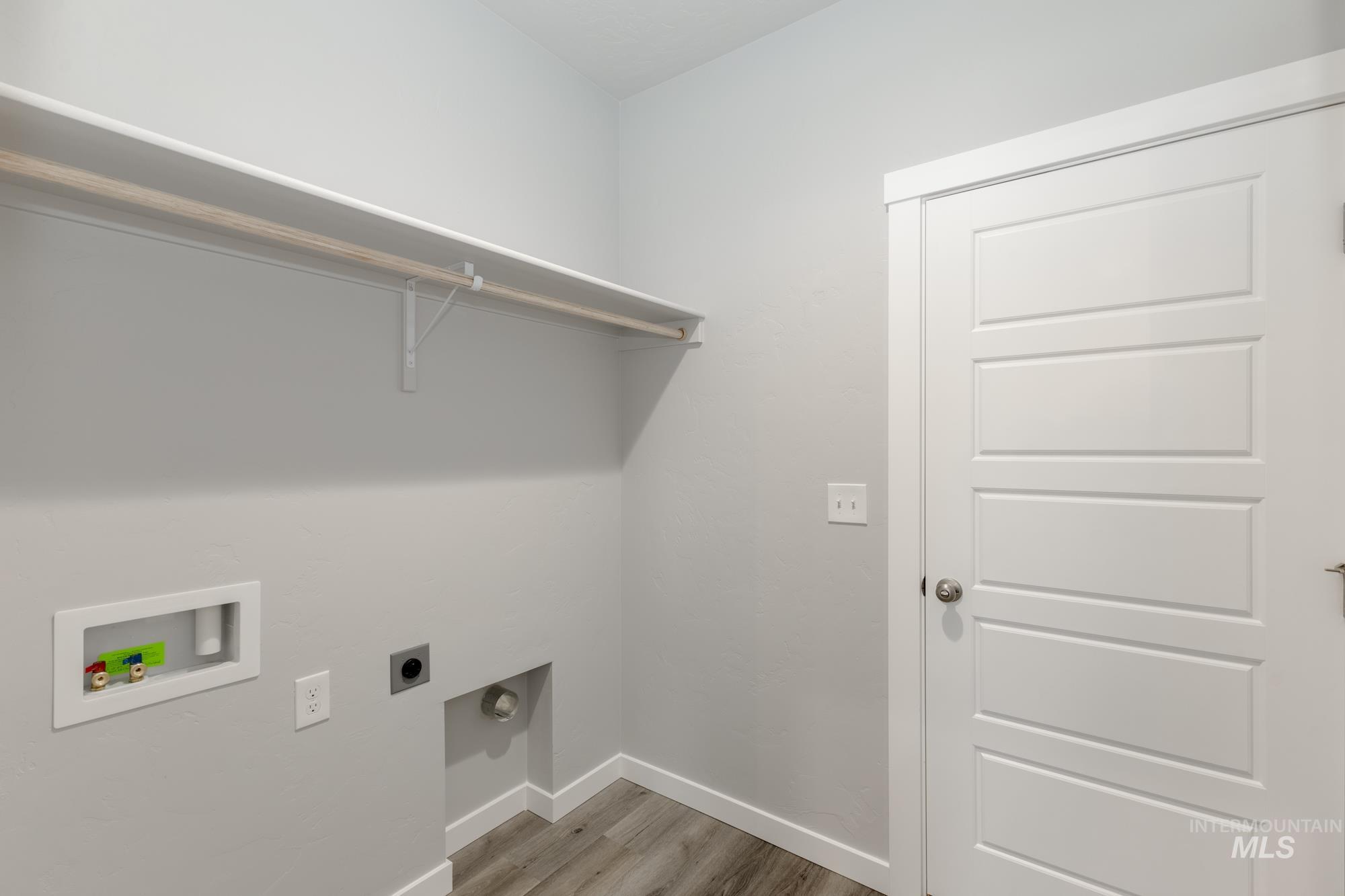 Laundry room featuring electric dryer hookup, washer hookup, and light wood-type flooring