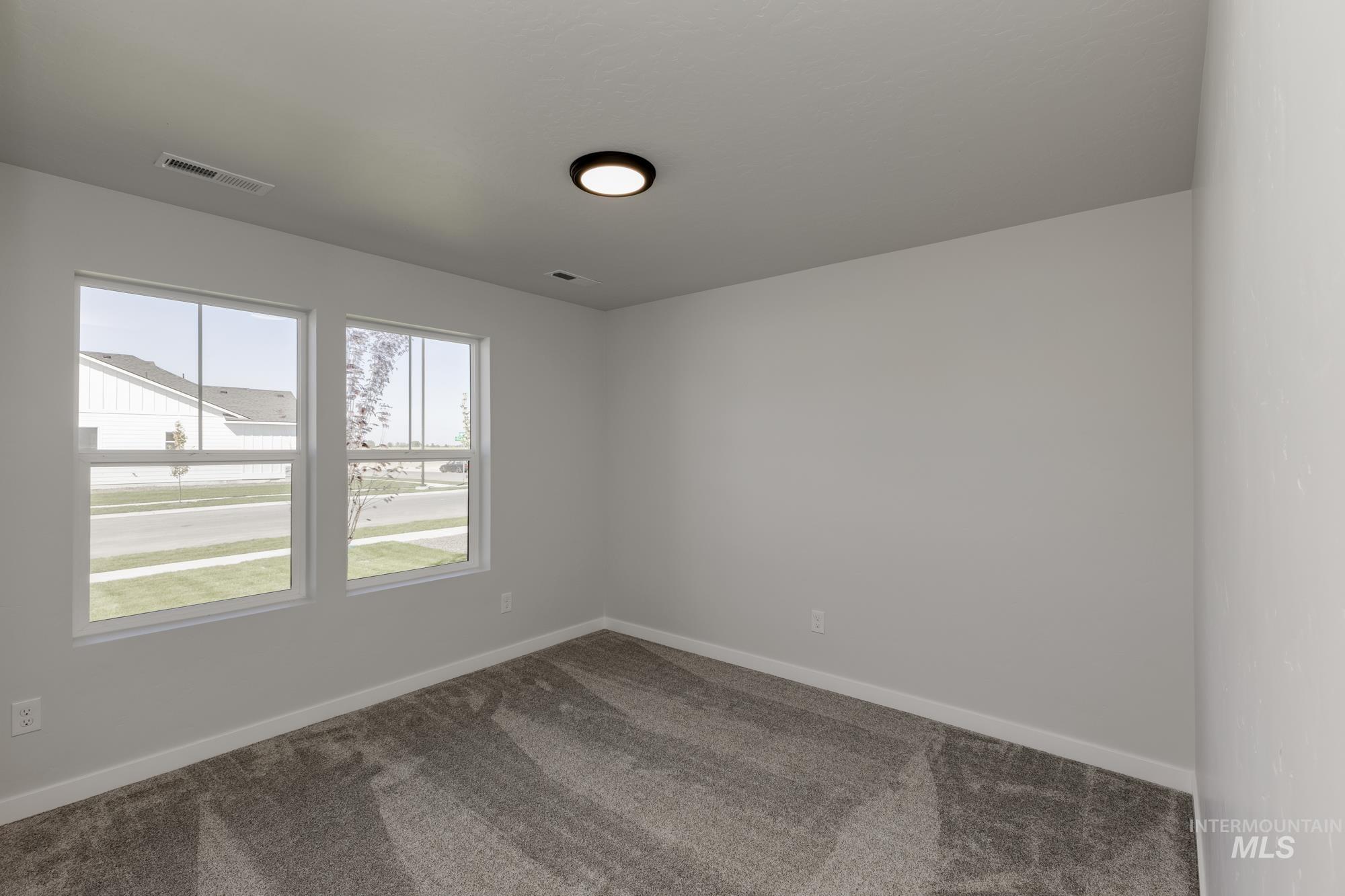 Spare room featuring carpet and baseboards