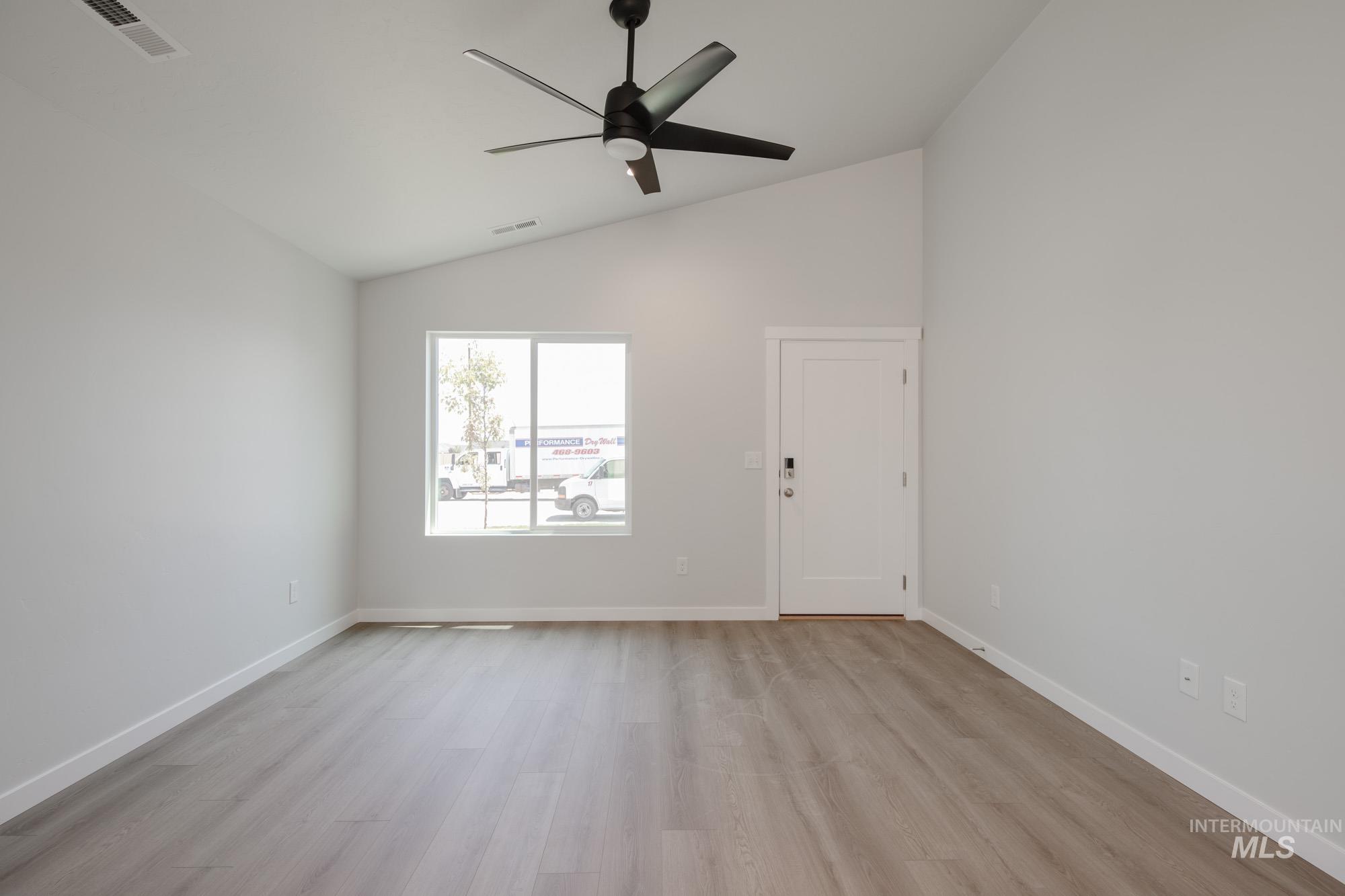 Unfurnished room with light wood-style flooring, ceiling fan, and high vaulted ceiling