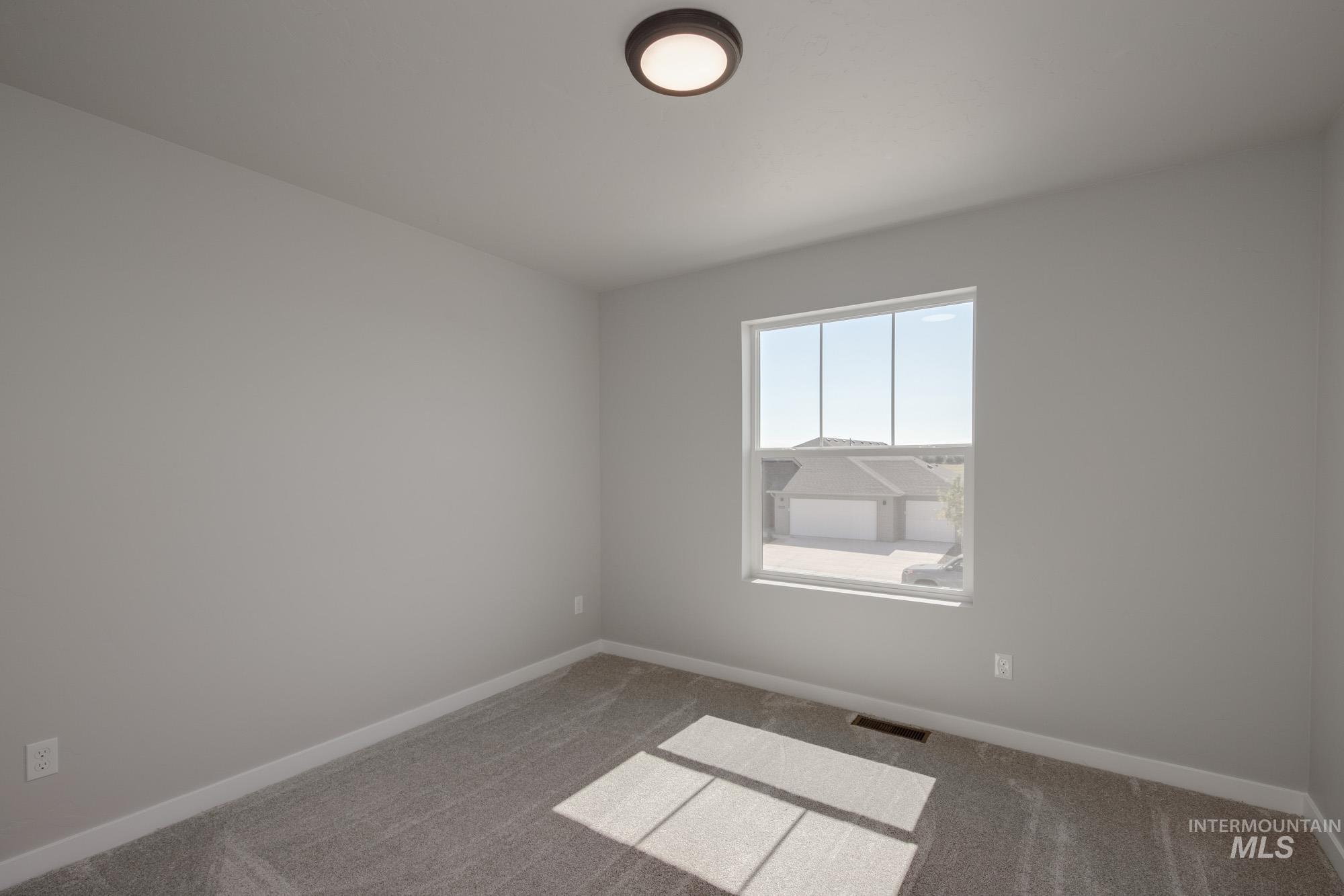 Carpeted empty room featuring baseboards