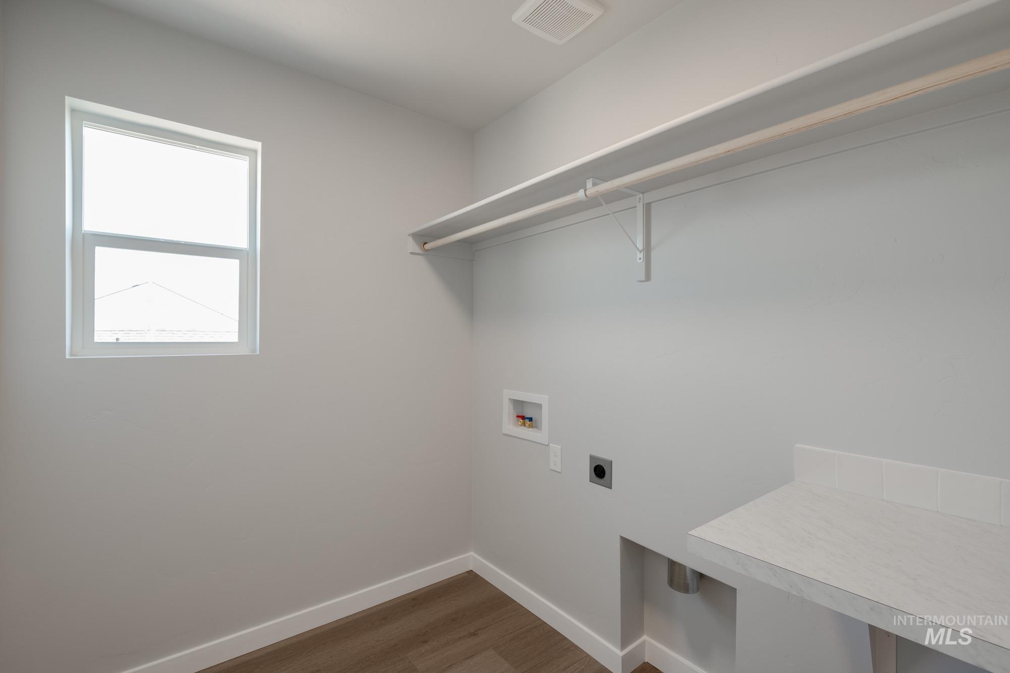 Laundry room featuring dark wood-style flooring, hookup for a washing machine, and hookup for an electric dryer