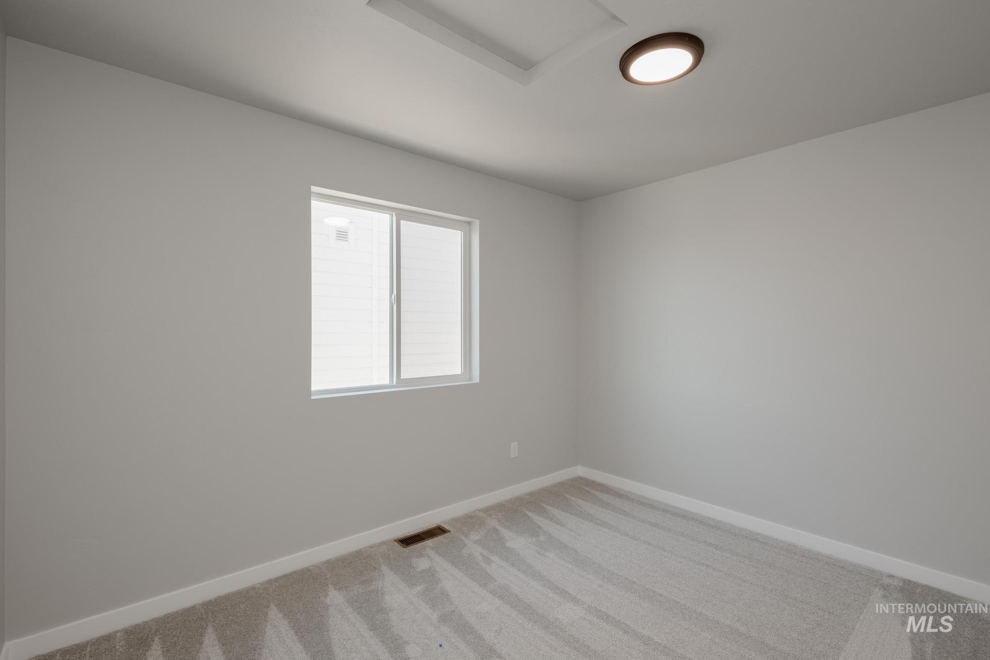 Unfurnished room with carpet floors and attic access