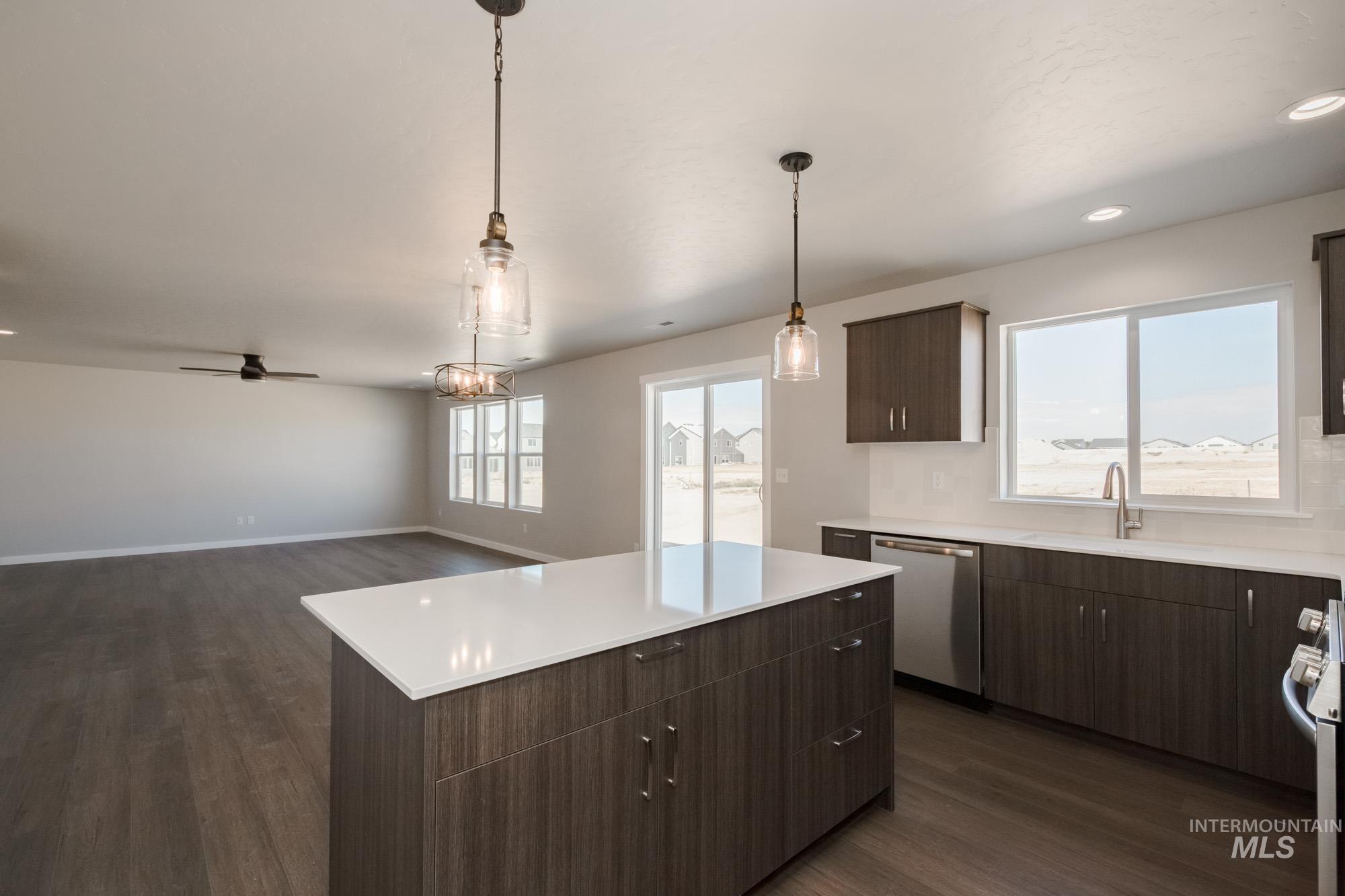 Kitchen with dark wood-style flooring, a center island, dark brown cabinets, dishwasher, and pendant lighting