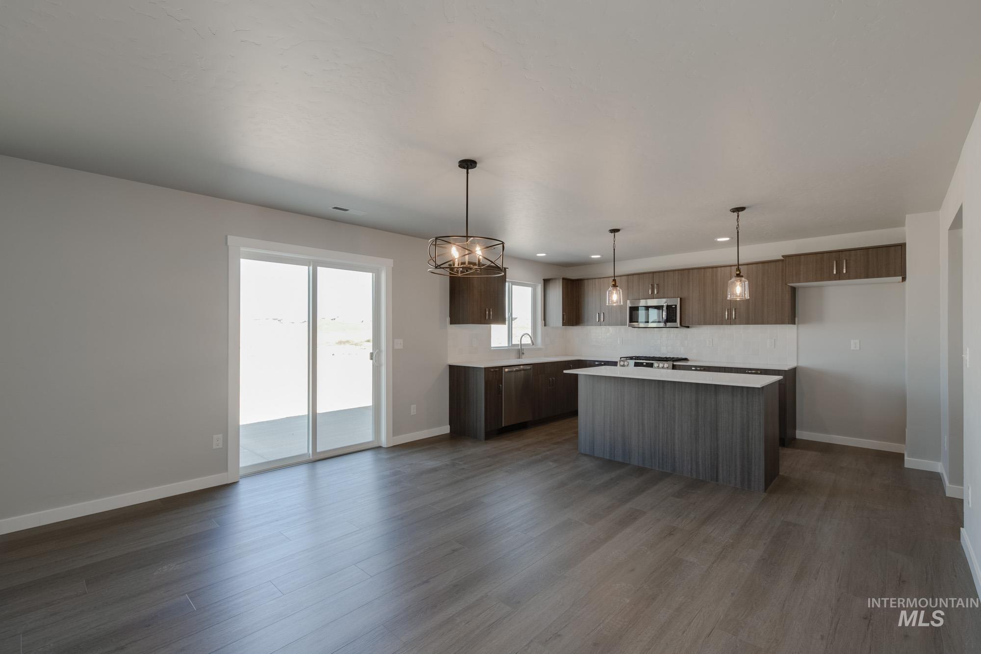 Kitchen with pendant lighting, a center island, decorative backsplash, dark wood-style flooring, and recessed lighting