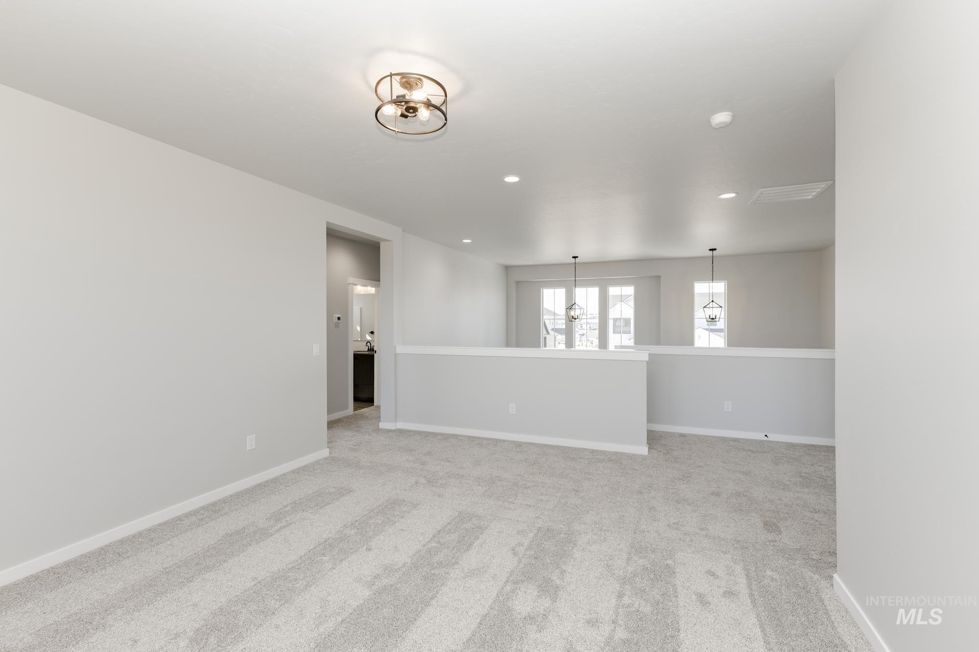 Spare room with light carpet, recessed lighting, and a chandelier