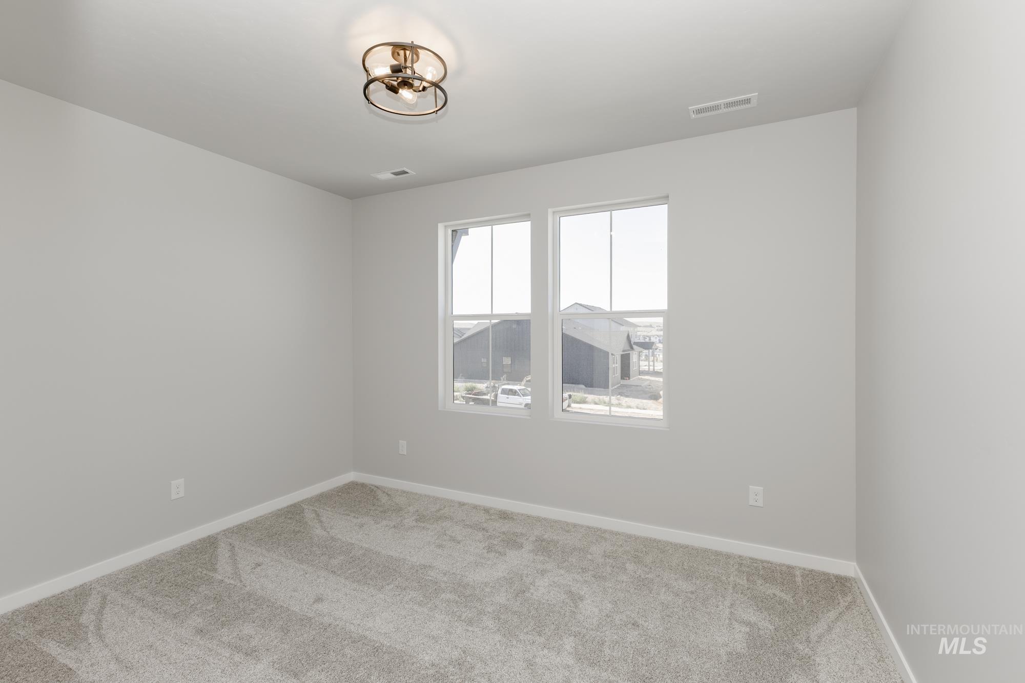 Spare room featuring carpet floors and baseboards