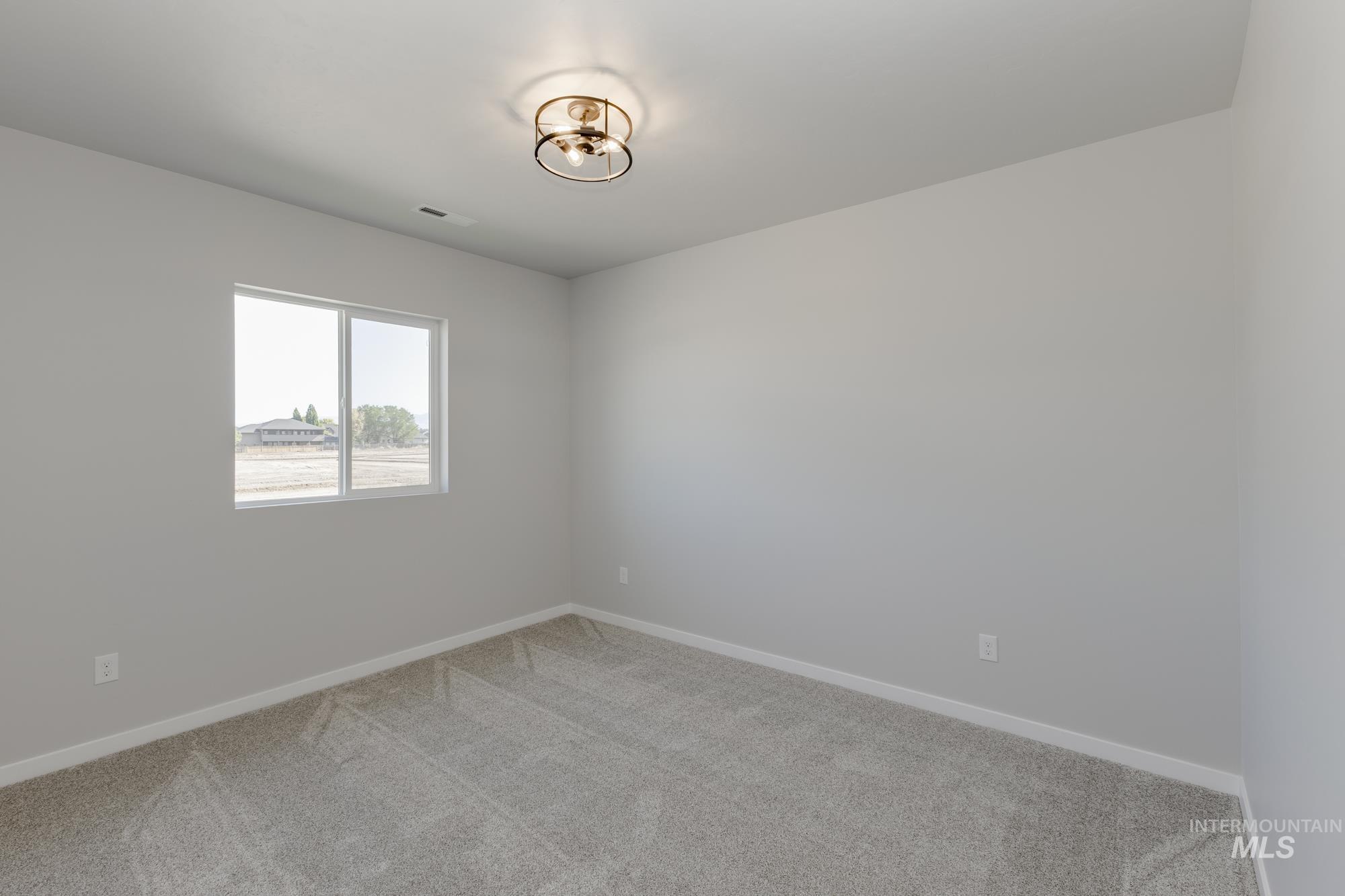 Carpeted spare room with baseboards
