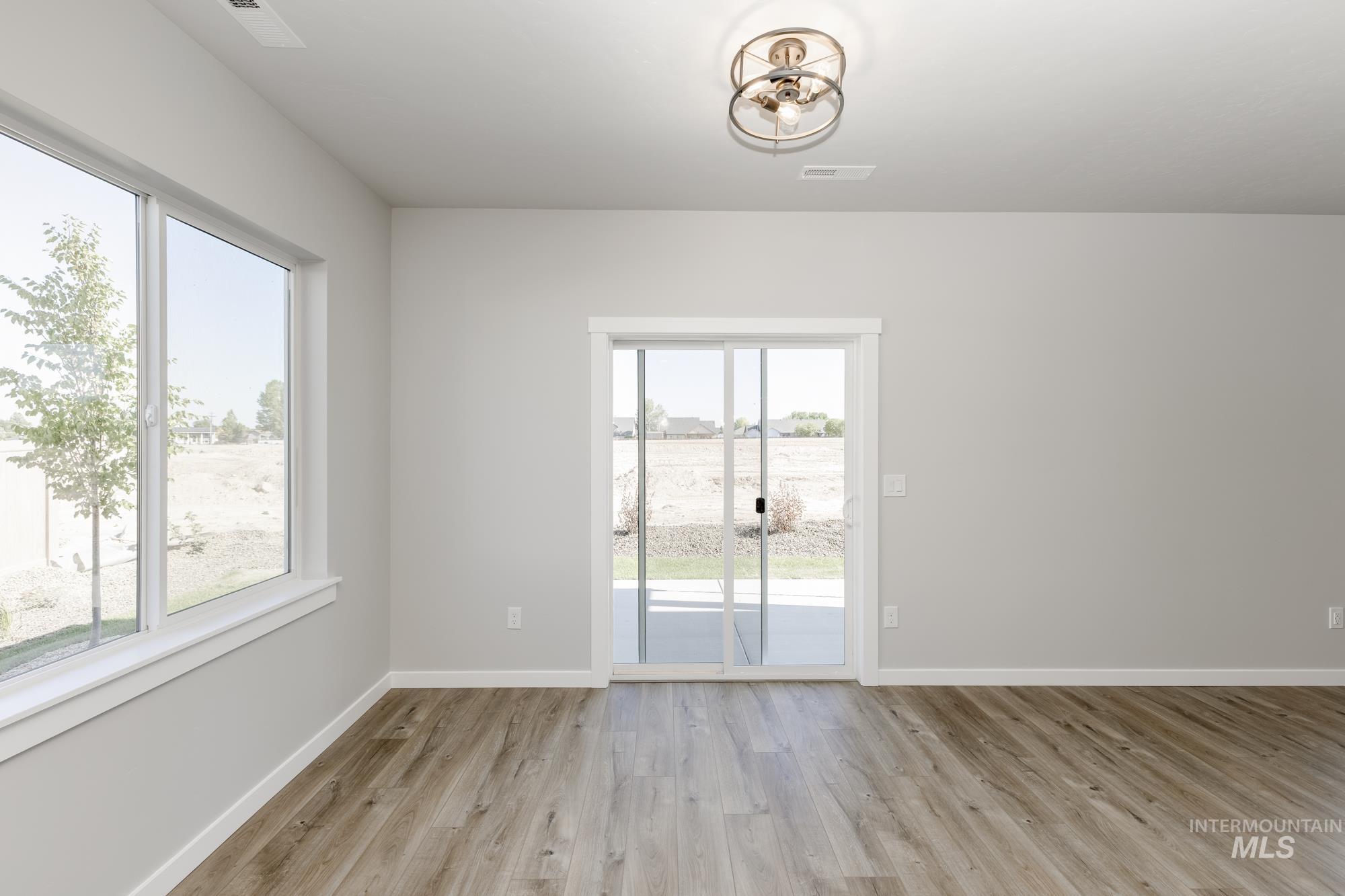 Spare room with light wood-style floors and baseboards