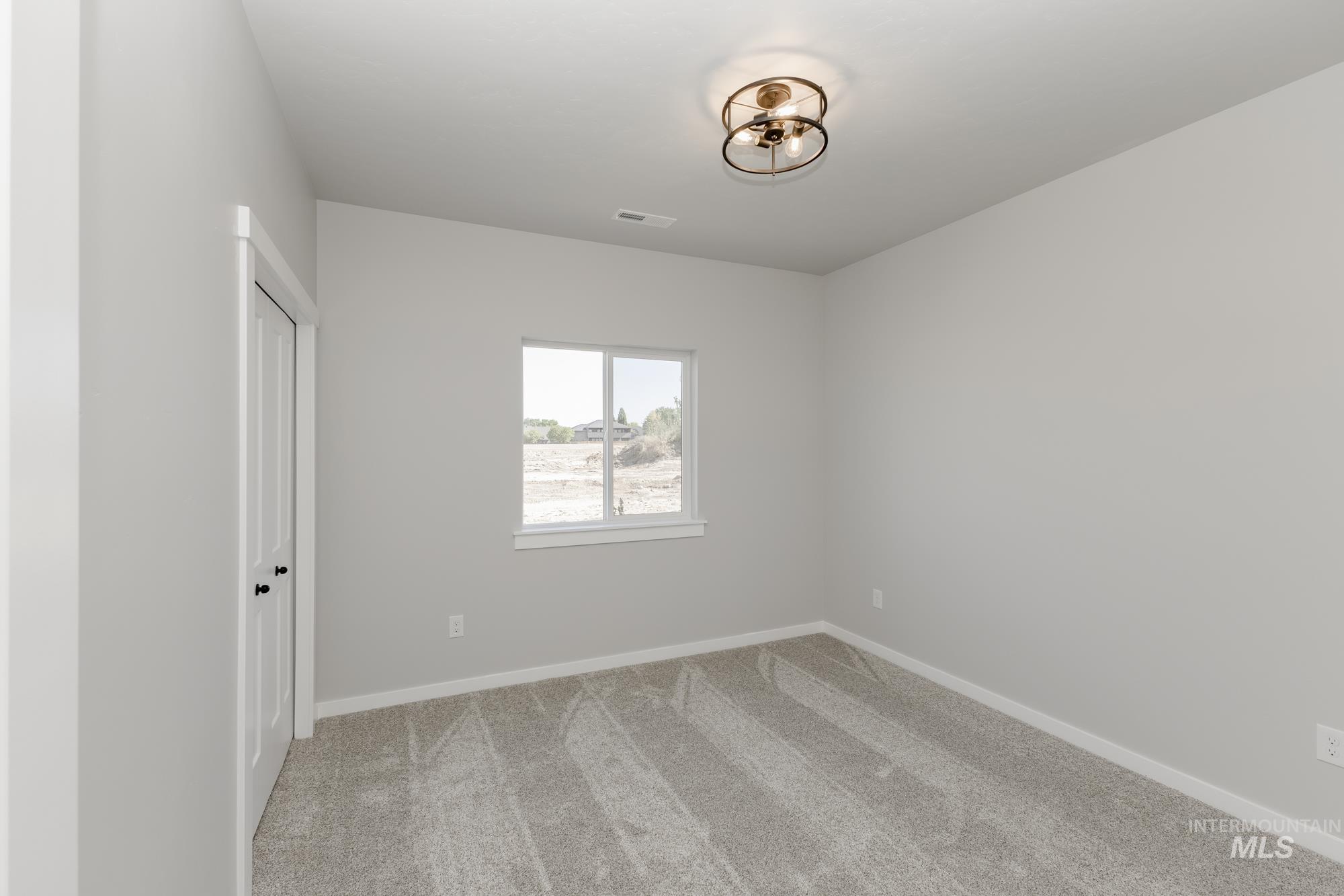 Unfurnished bedroom featuring light carpet and baseboards