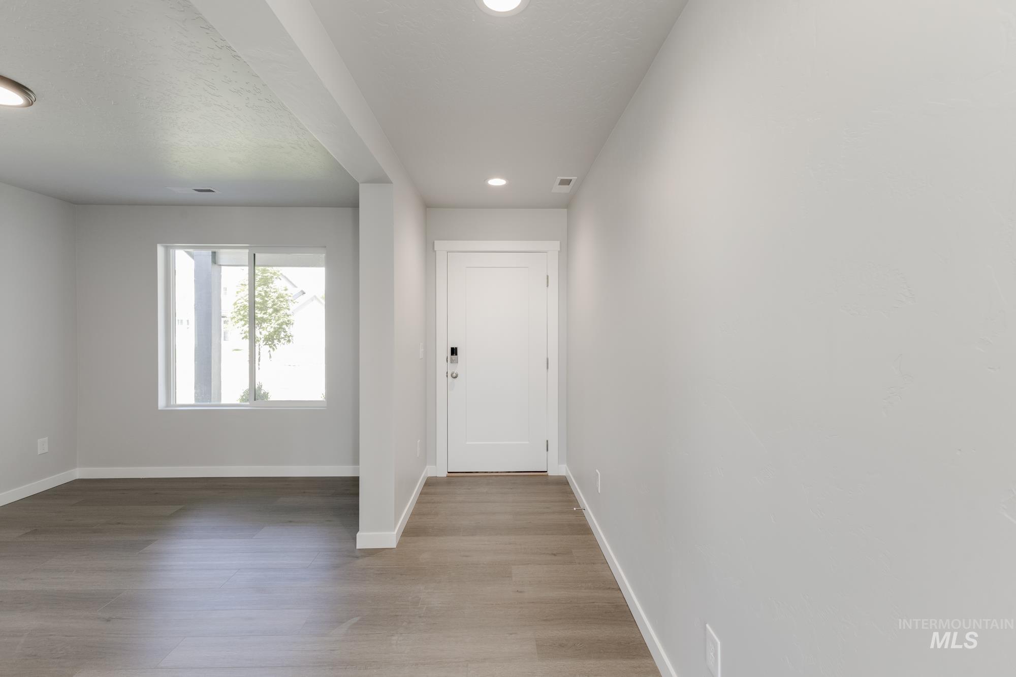 Entryway with light wood-type flooring and recessed lighting
