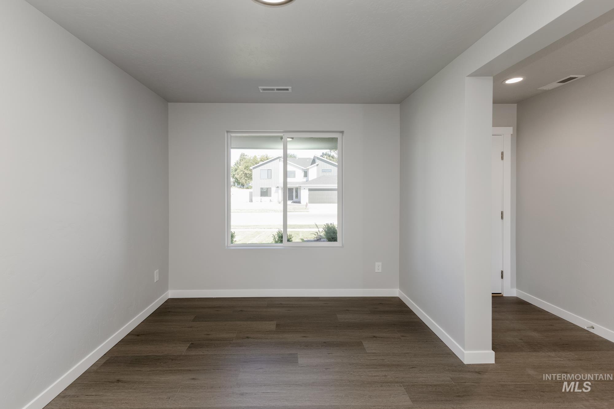 Spare room featuring dark wood-style floors and recessed lighting