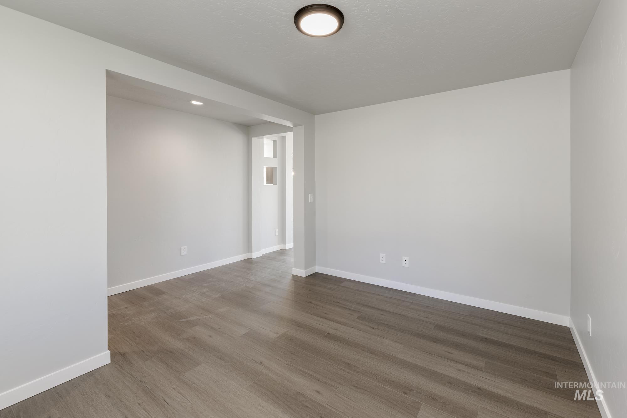 Unfurnished room with wood finished floors and recessed lighting