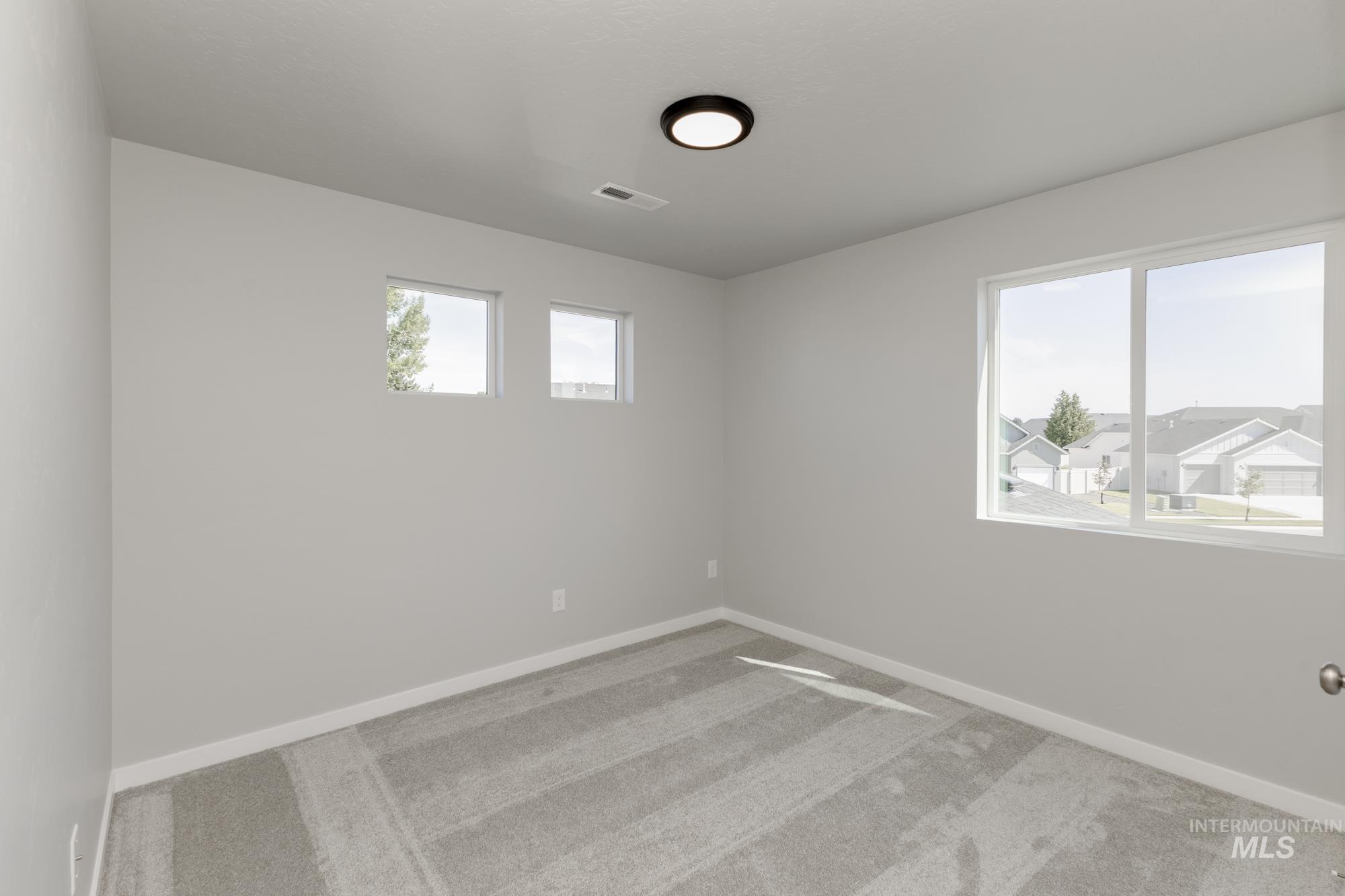Carpeted empty room with baseboards