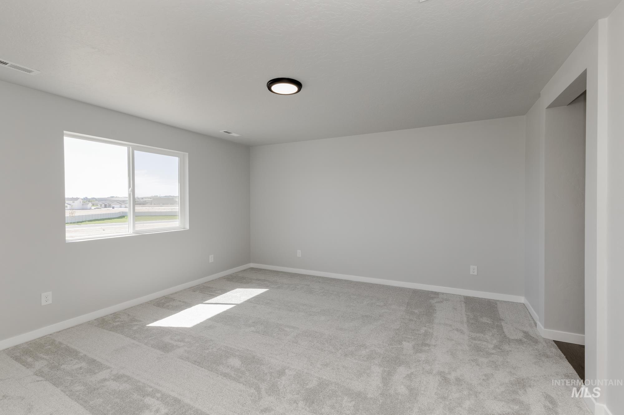 Unfurnished room with light colored carpet and baseboards