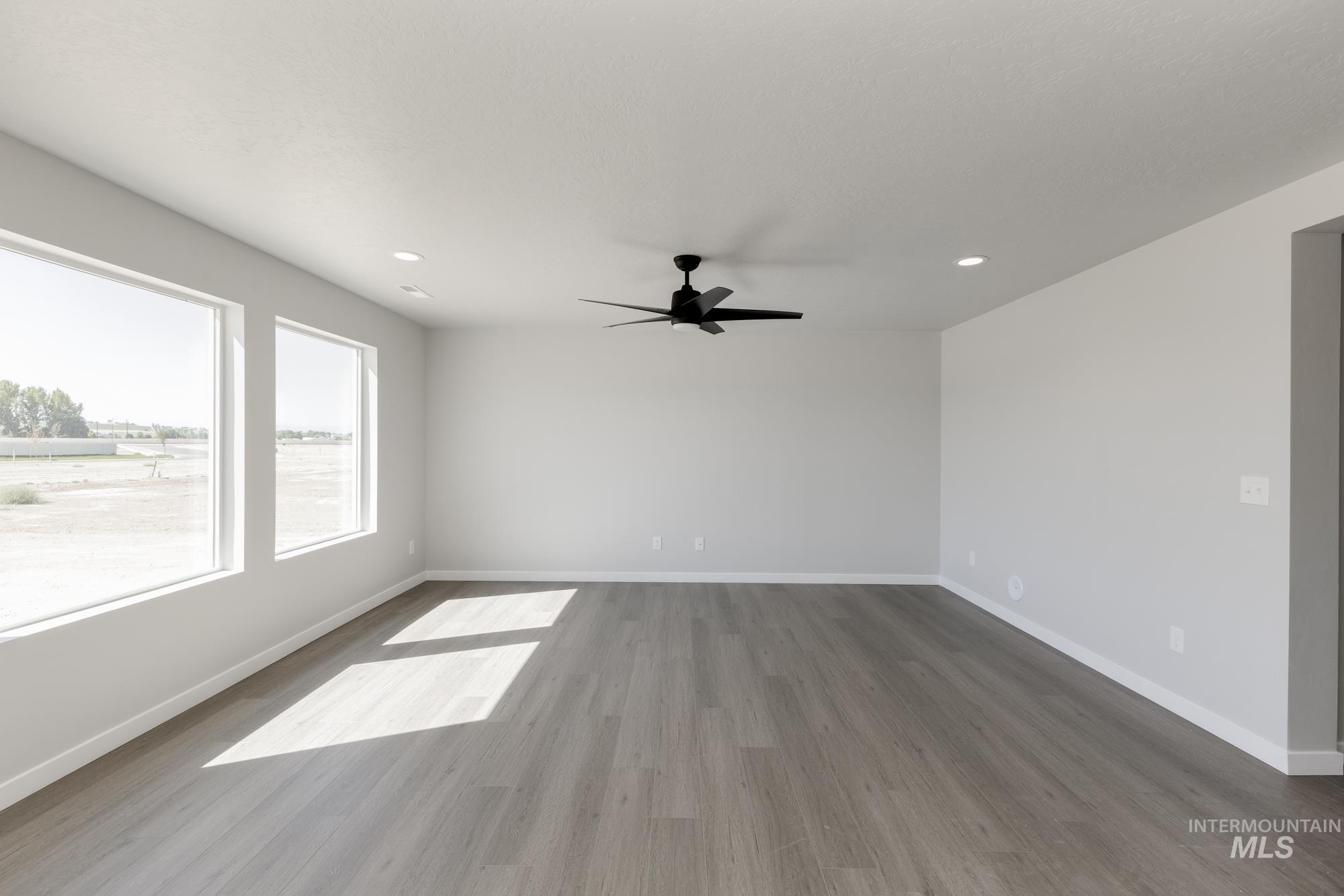 Spare room featuring wood finished floors, recessed lighting, and a ceiling fan