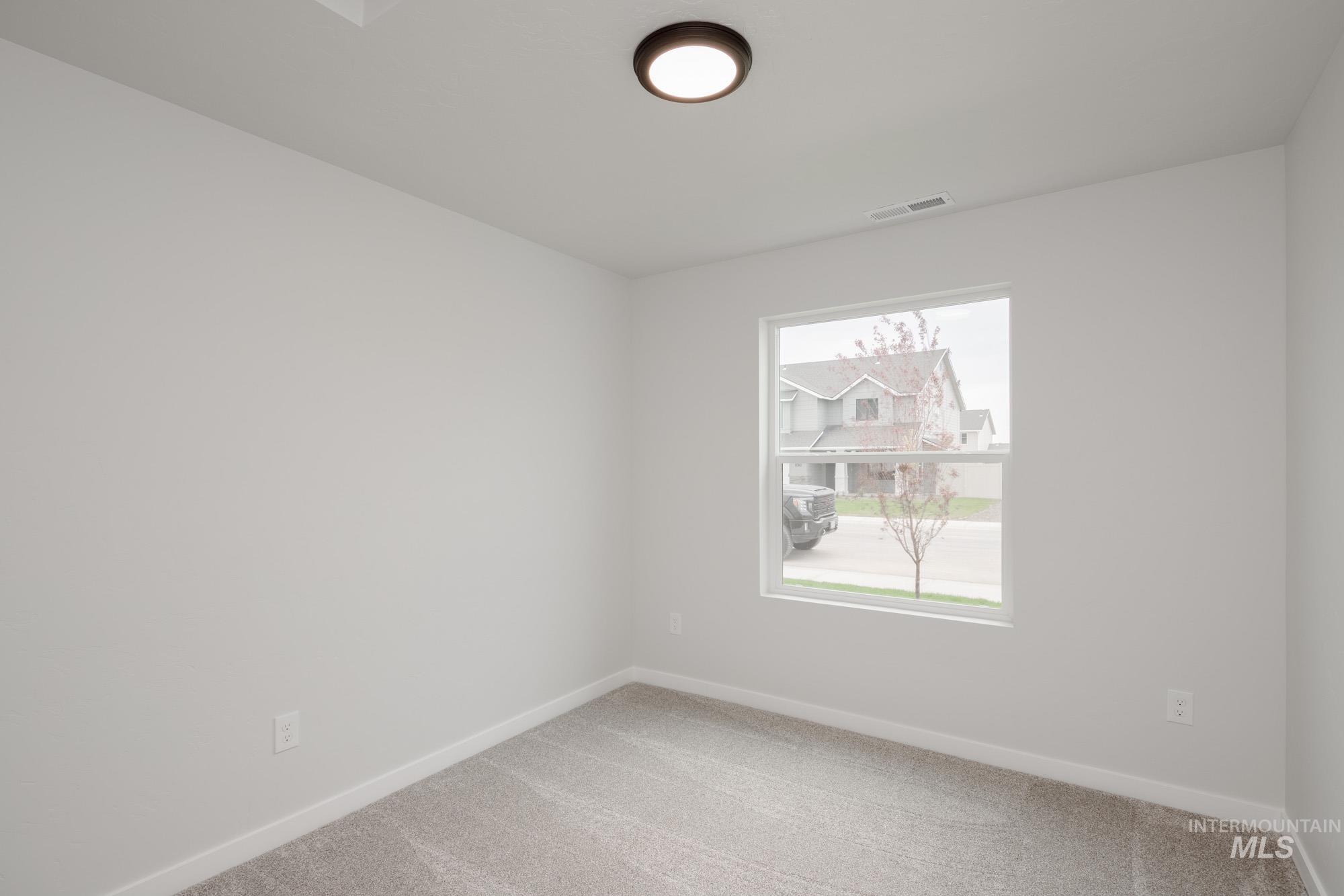 Carpeted empty room featuring baseboards